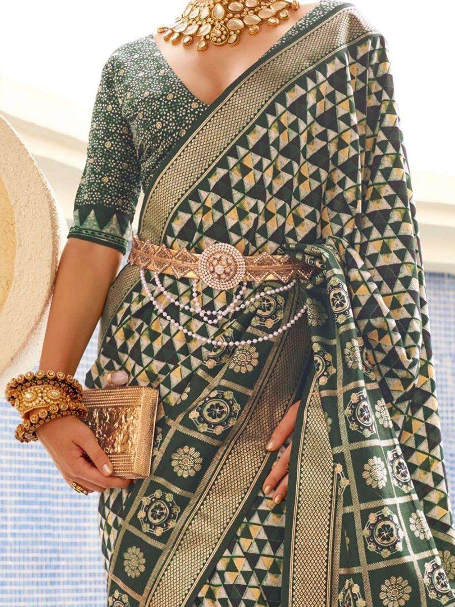 Green geometric print saree with gold embroidery, paired with statement jewelry and clutch, perfect for ethnic occasions