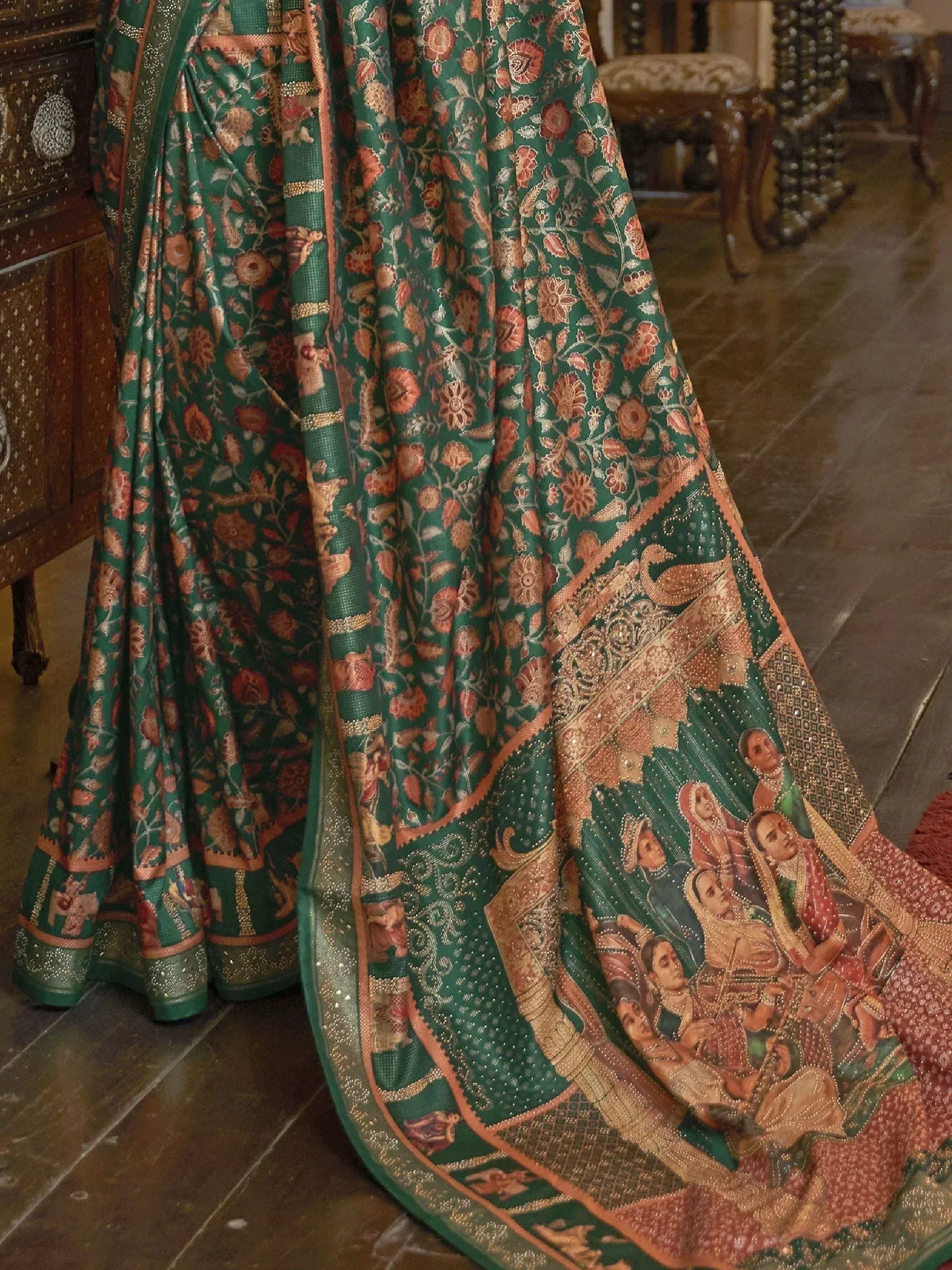 Emerald green designer saree with intricate floral and royal court motifs, perfect for ethnic occasions.