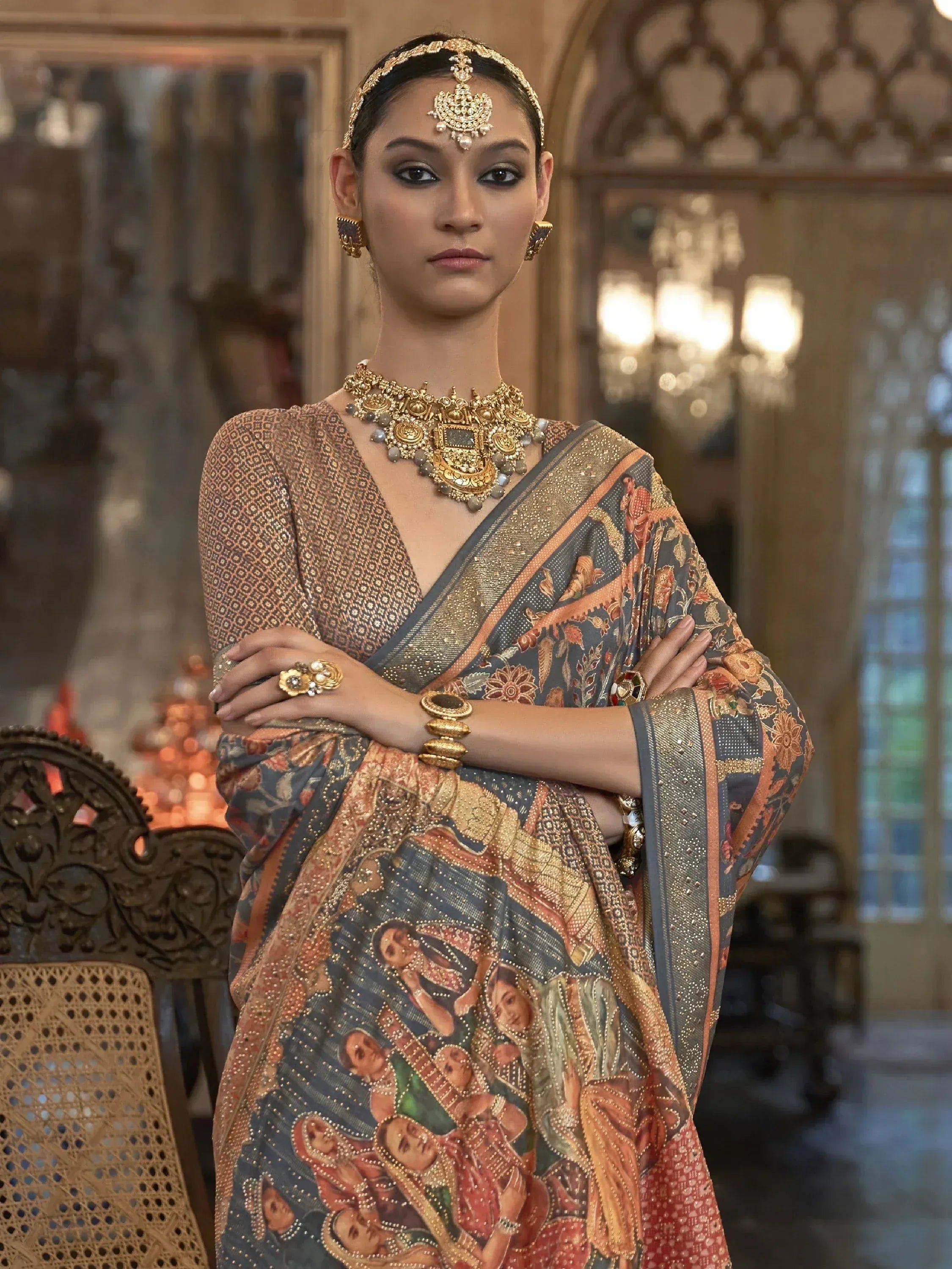Woman in designer saree with intricate print and gold jewelry, ethnic wear for special occasions