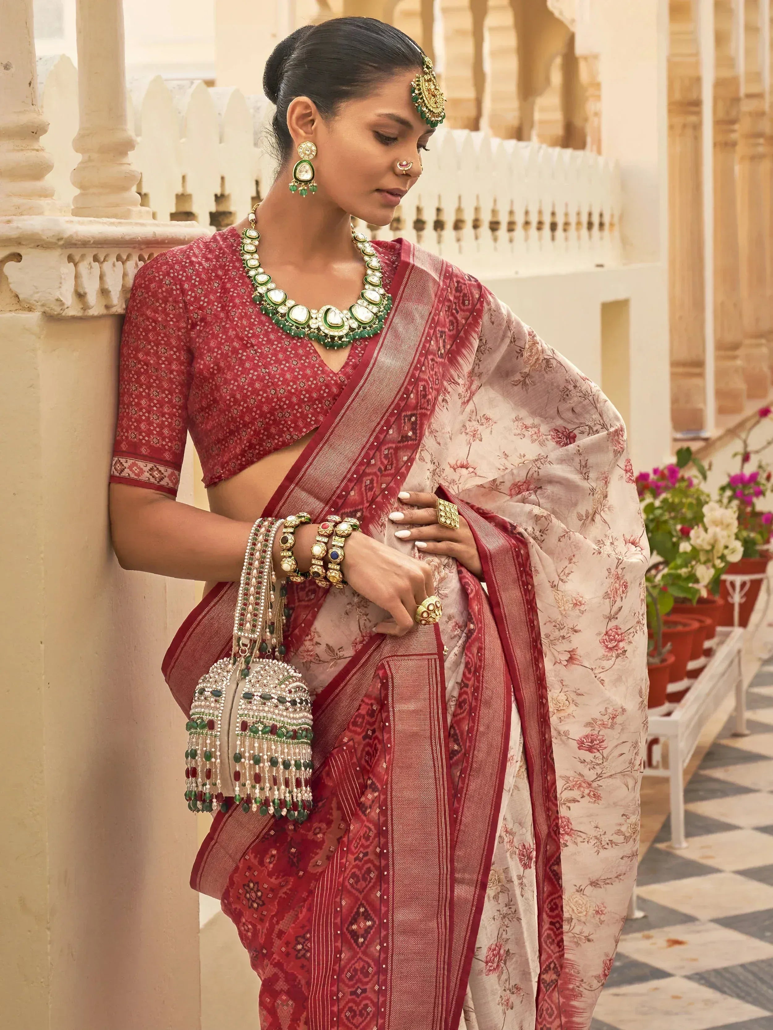 Woman in red floral saree with matching blouse and traditional Indian jewelry, perfect for ethnic occasions