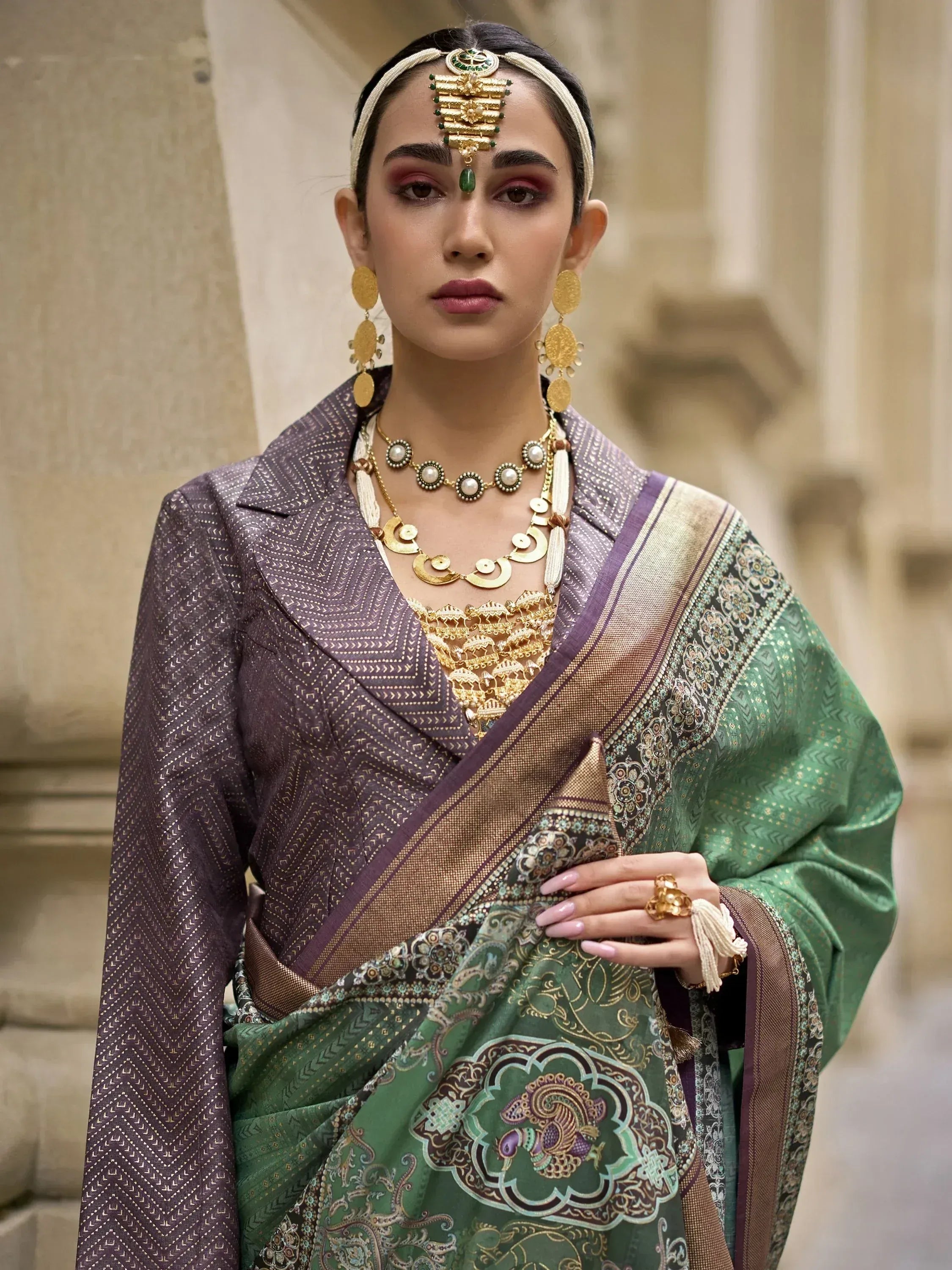 Woman in green printed saree with gold embroidery, purple blouse, and traditional Indian jewelry