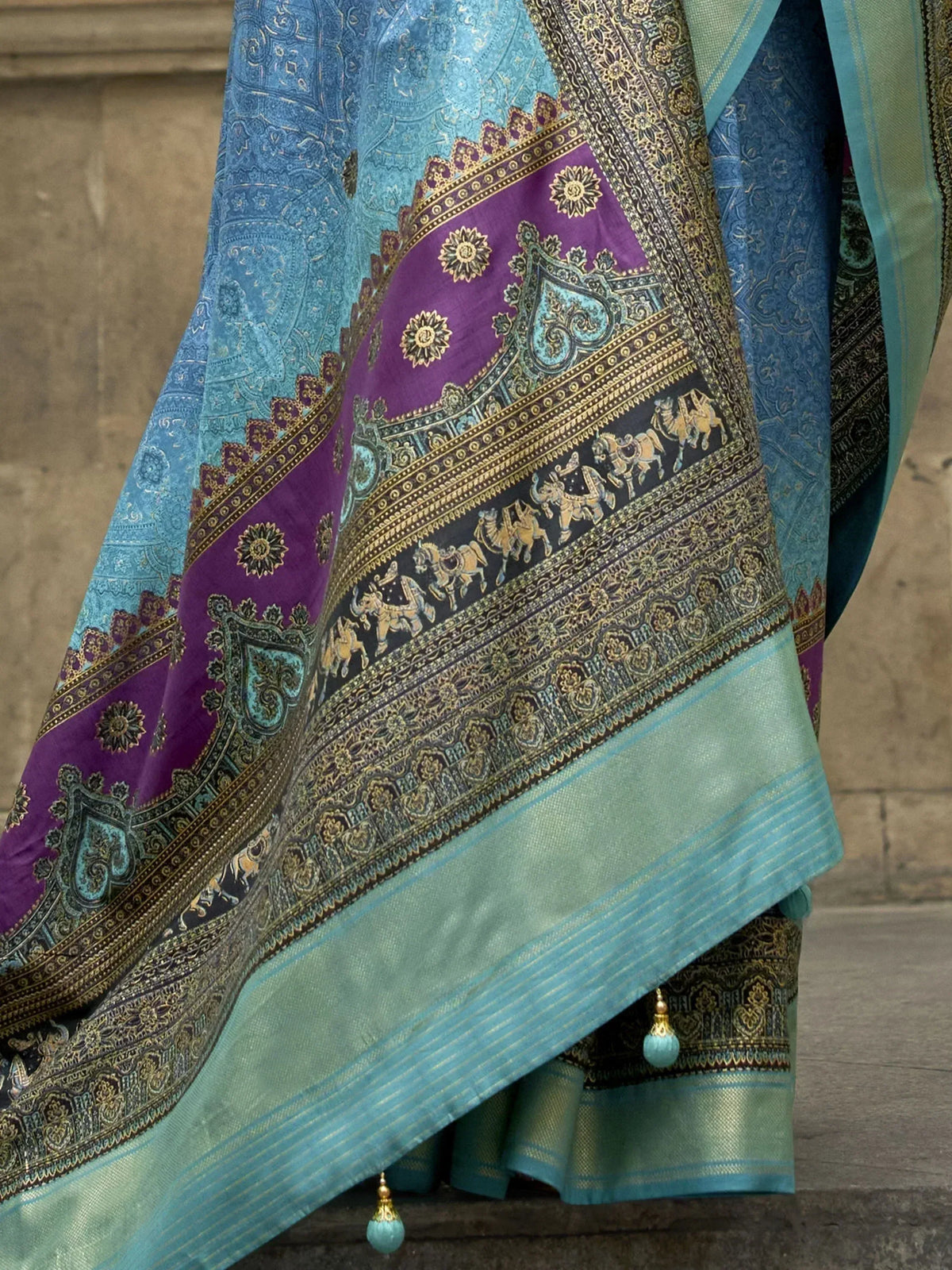 Blue and purple designer saree with gold elephant motifs and intricate border, perfect for ethnic occasions