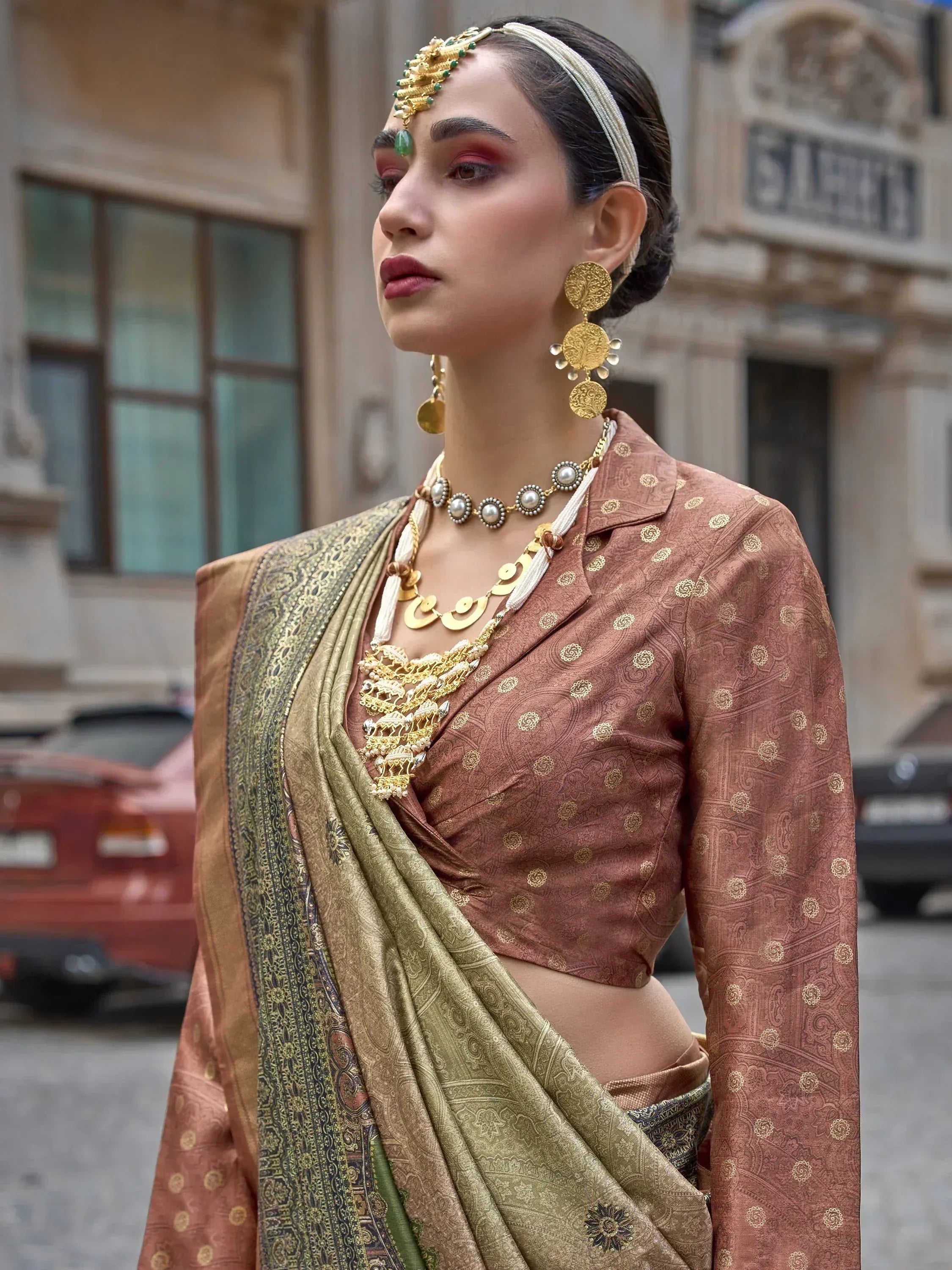 Woman in traditional Indian saree with gold jewelry and headpiece, ethnic wear