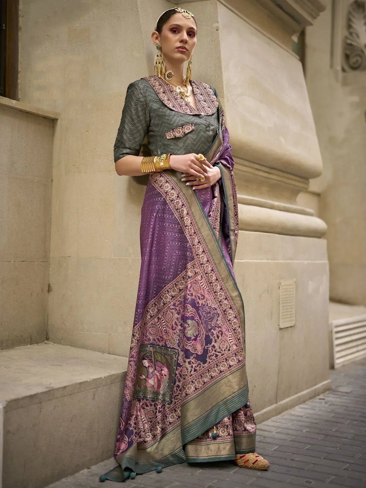 Woman in purple and green designer saree with intricate embroidery and traditional jewelry, styled for ethnic occasions