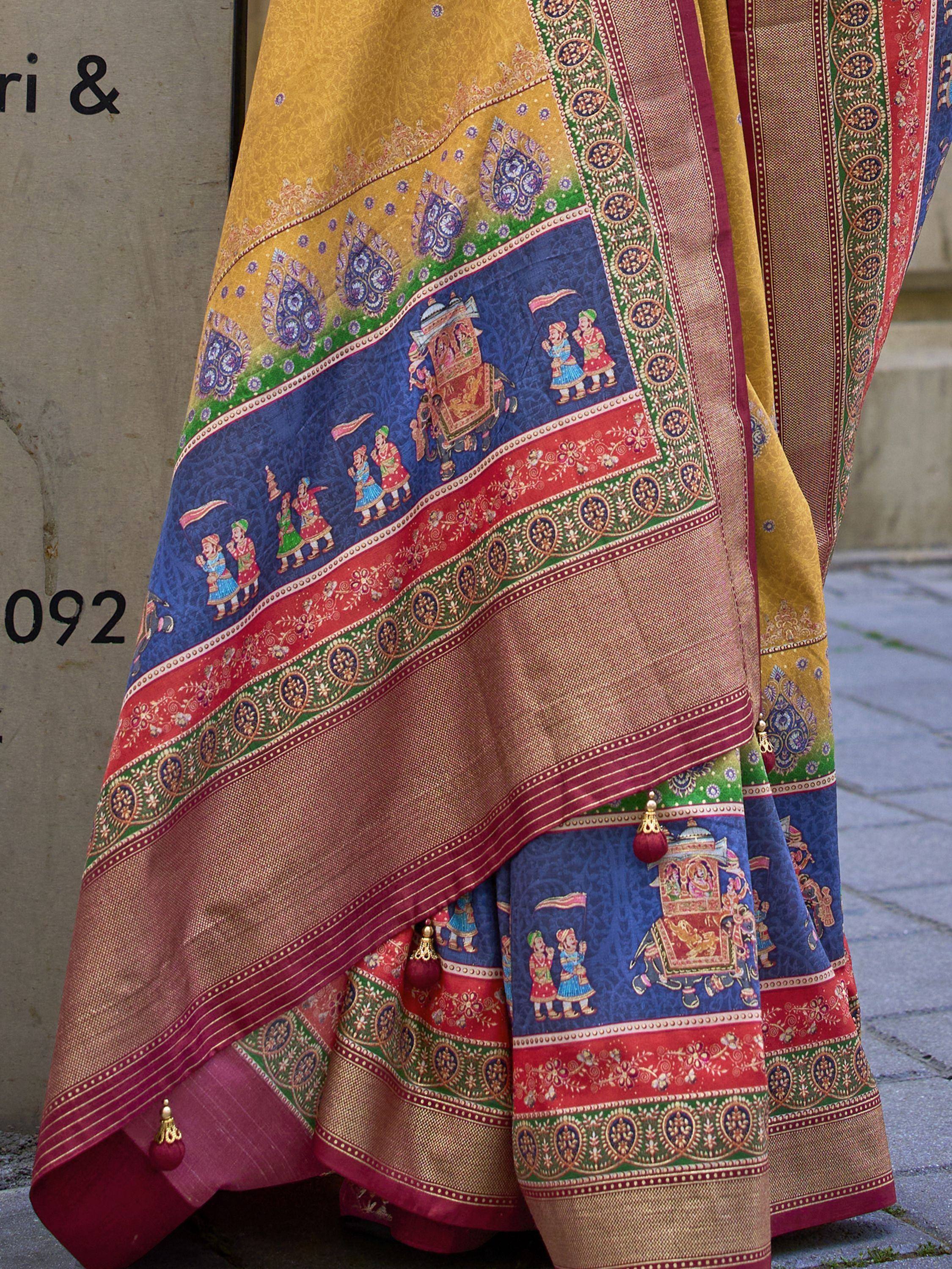 Vibrant Indian saree with royal procession print, rich gold, blue, red, and green borders, traditional ethnic wear