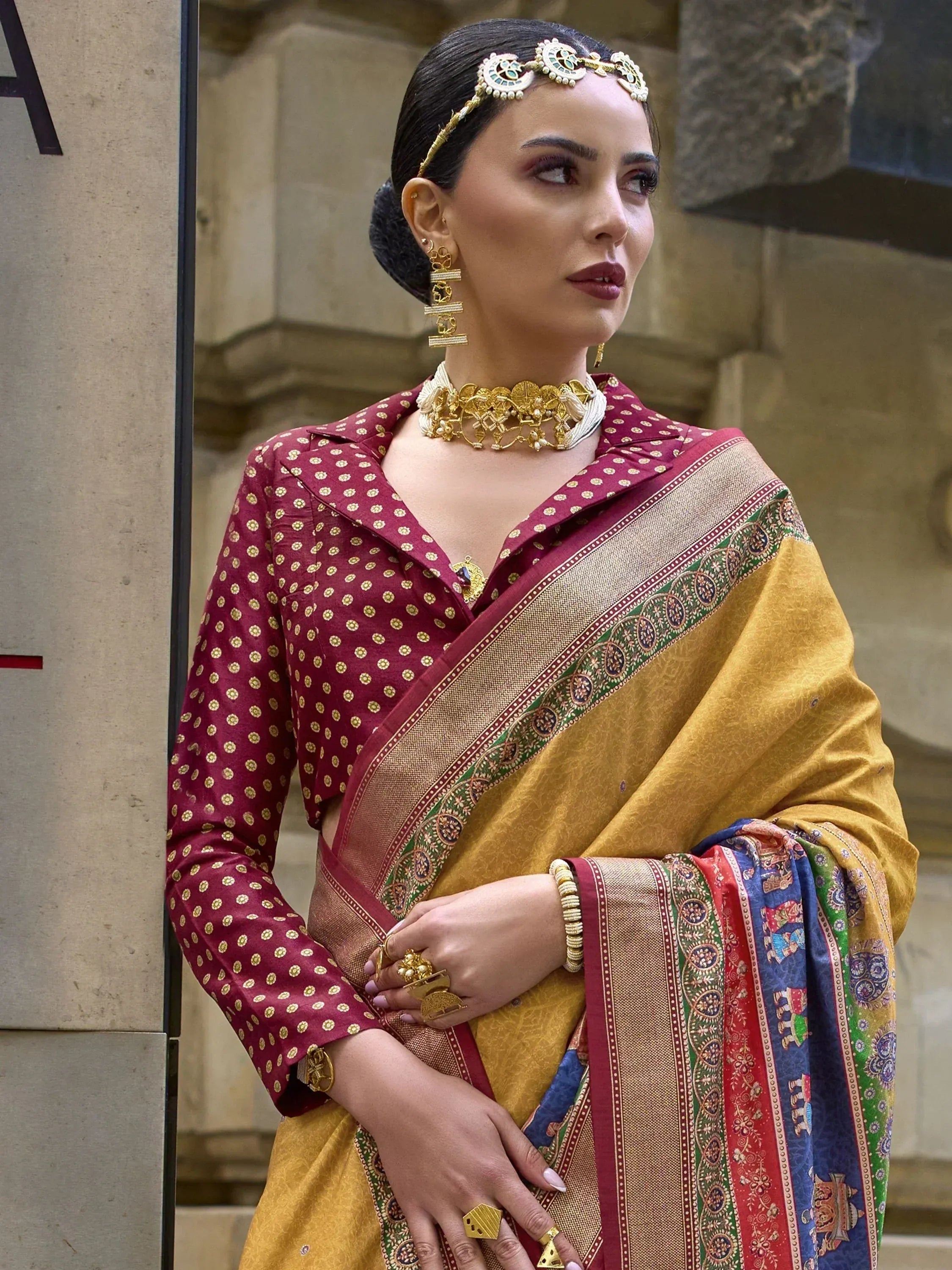 Woman in maroon polka dot blouse with golden saree, traditional Indian ethnic wear, gold jewelry
