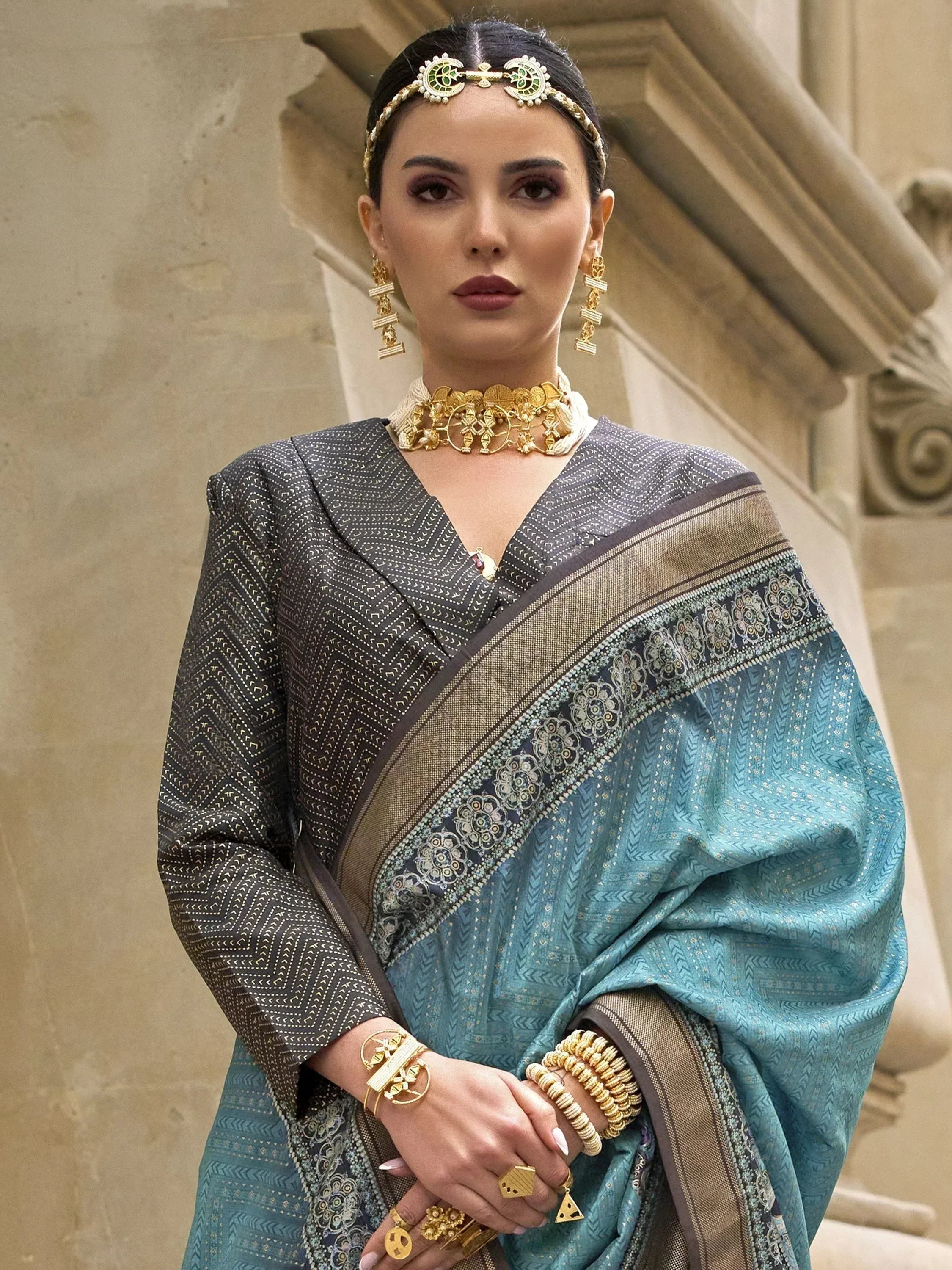 Elegant woman in designer saree with gold jewelry, showcasing Indian ethnic wear for festive occasions.
