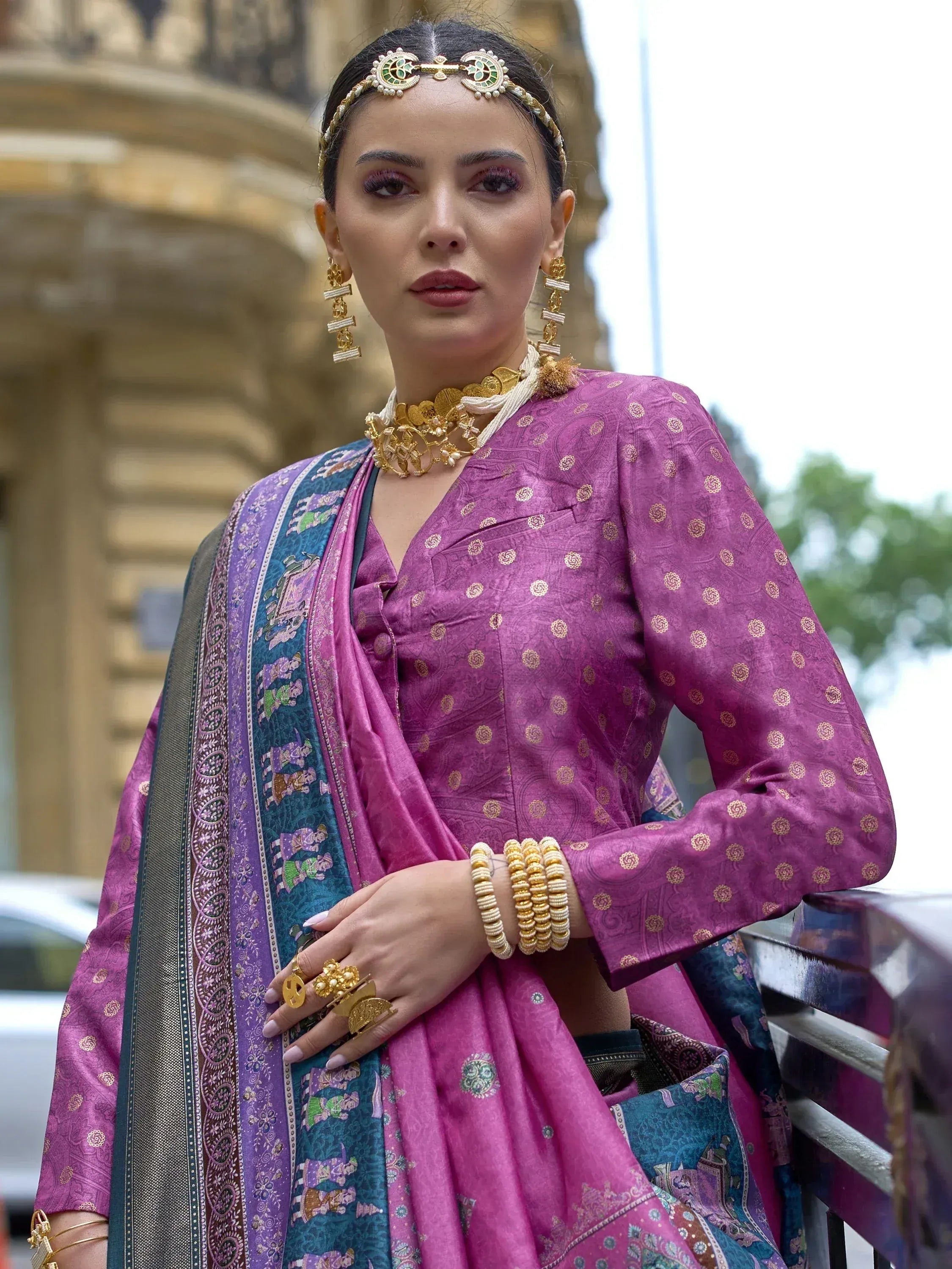 Woman in purple ethnic salwar kameez with gold embroidery, traditional jewelry, and printed dupatta