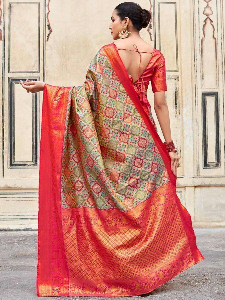 Woman in vibrant red and green patterned saree with elephant border, back view, ethnic Indian wear