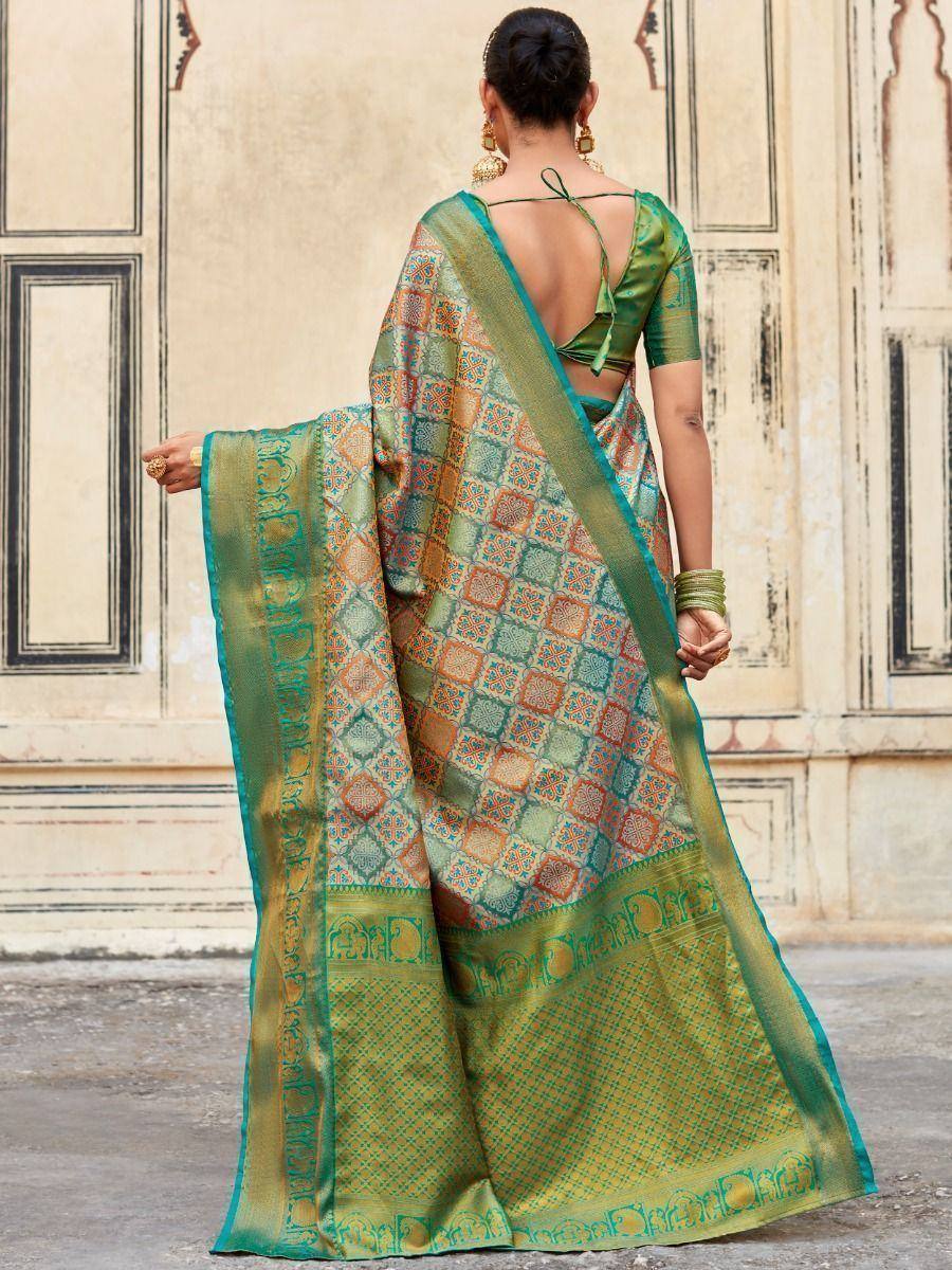 Green and orange patterned saree with intricate border design, worn with a backless blouse