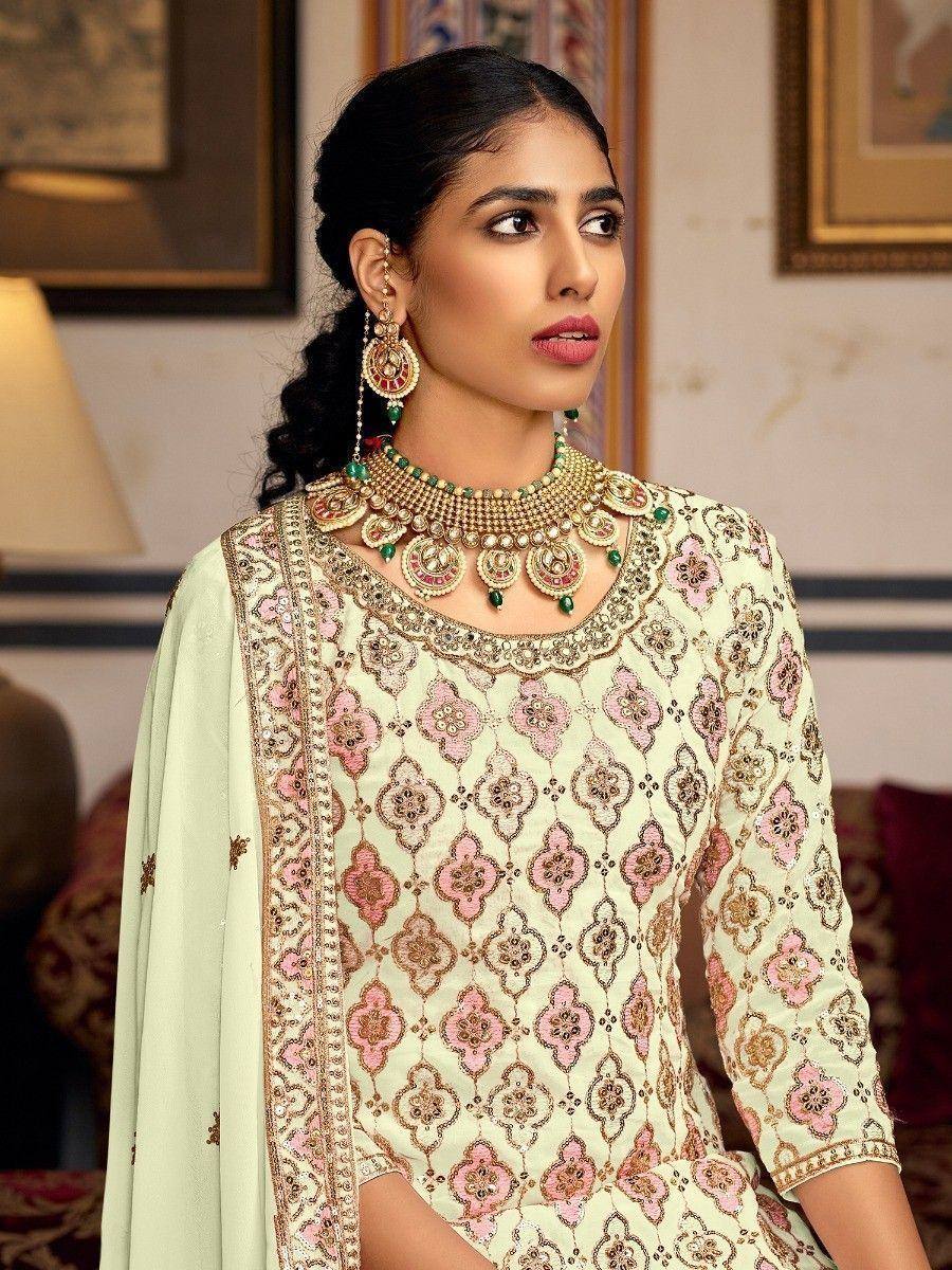 Elegant cream and pink embroidered salwar kameez with matching jewelry, perfect for Indian ethnic occasions