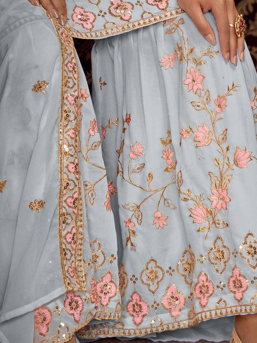 Light blue ethnic lehenga with pink and gold floral embroidery, perfect for Indian weddings or festivals