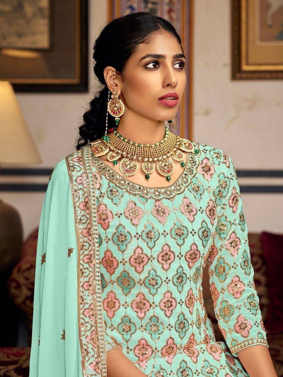 Mint green designer salwar kameez with pink floral embroidery and gold detailing, paired with traditional jewelry