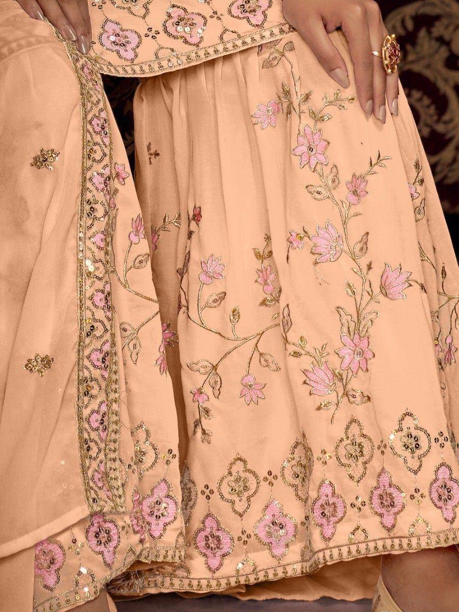 Peach ethnic lehenga with pink floral embroidery and gold detailing, perfect for Indian weddings or festive occasions.