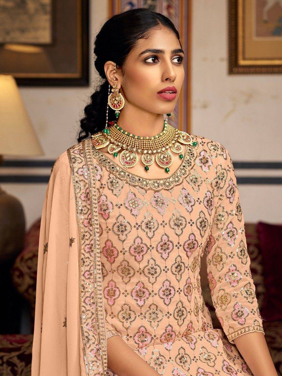 Elegant peach ethnic salwar kameez with floral embroidery and gold jewelry