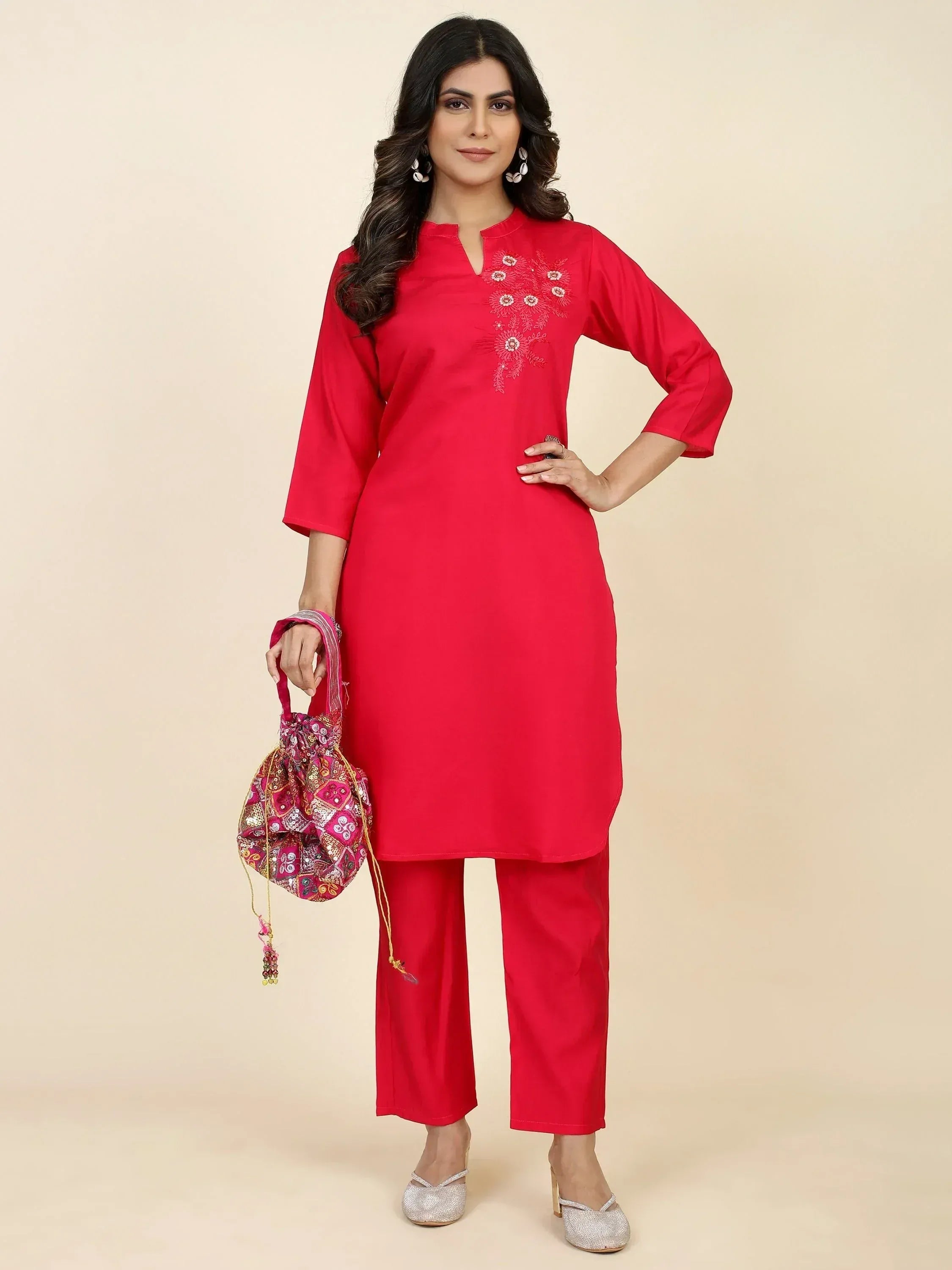 Red embroidered kurta with matching pants, ethnic wear for women, paired with embellished potli bag