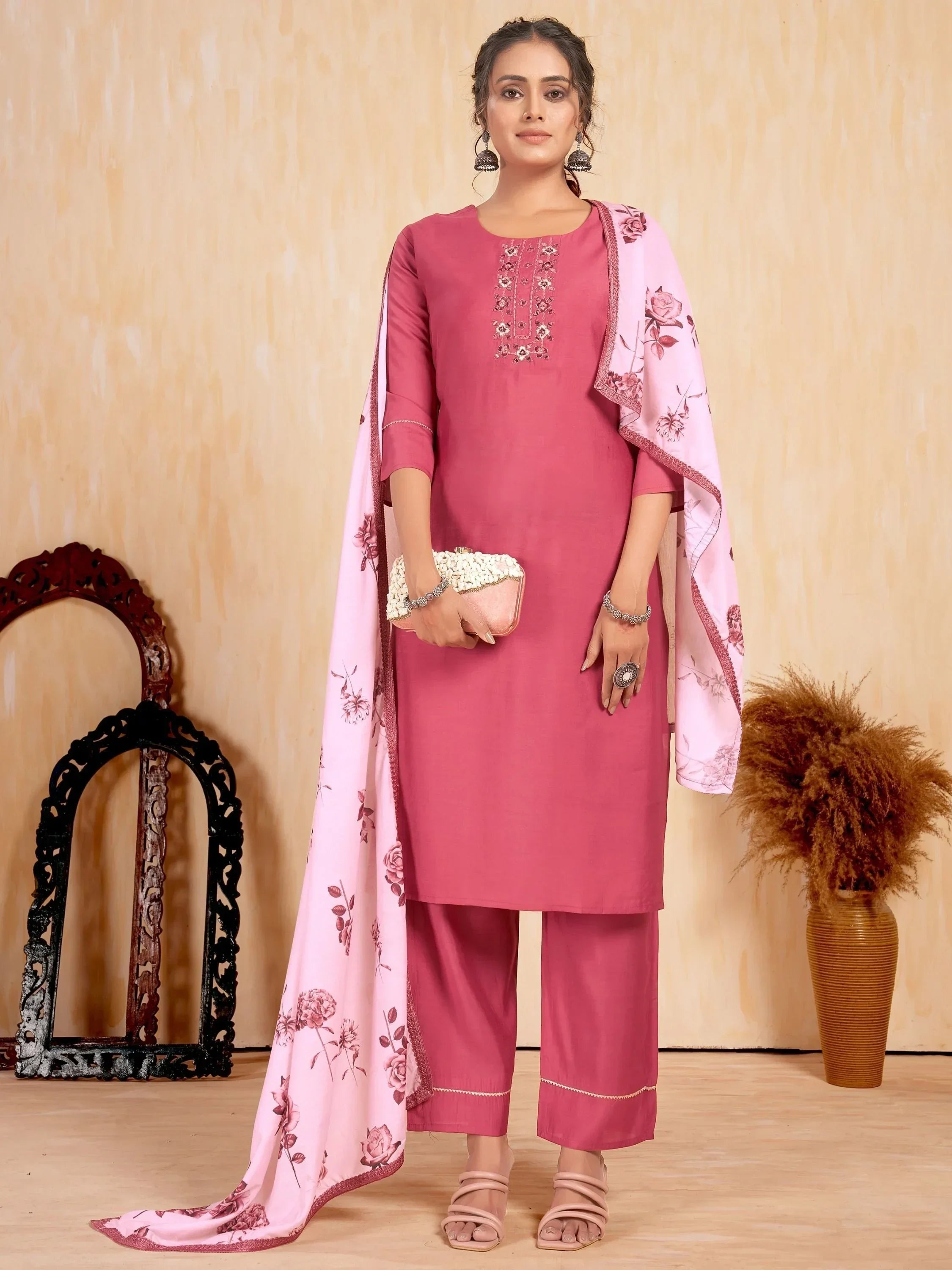 Woman wearing a pink embroidered kurta set with floral dupatta and matching pants
