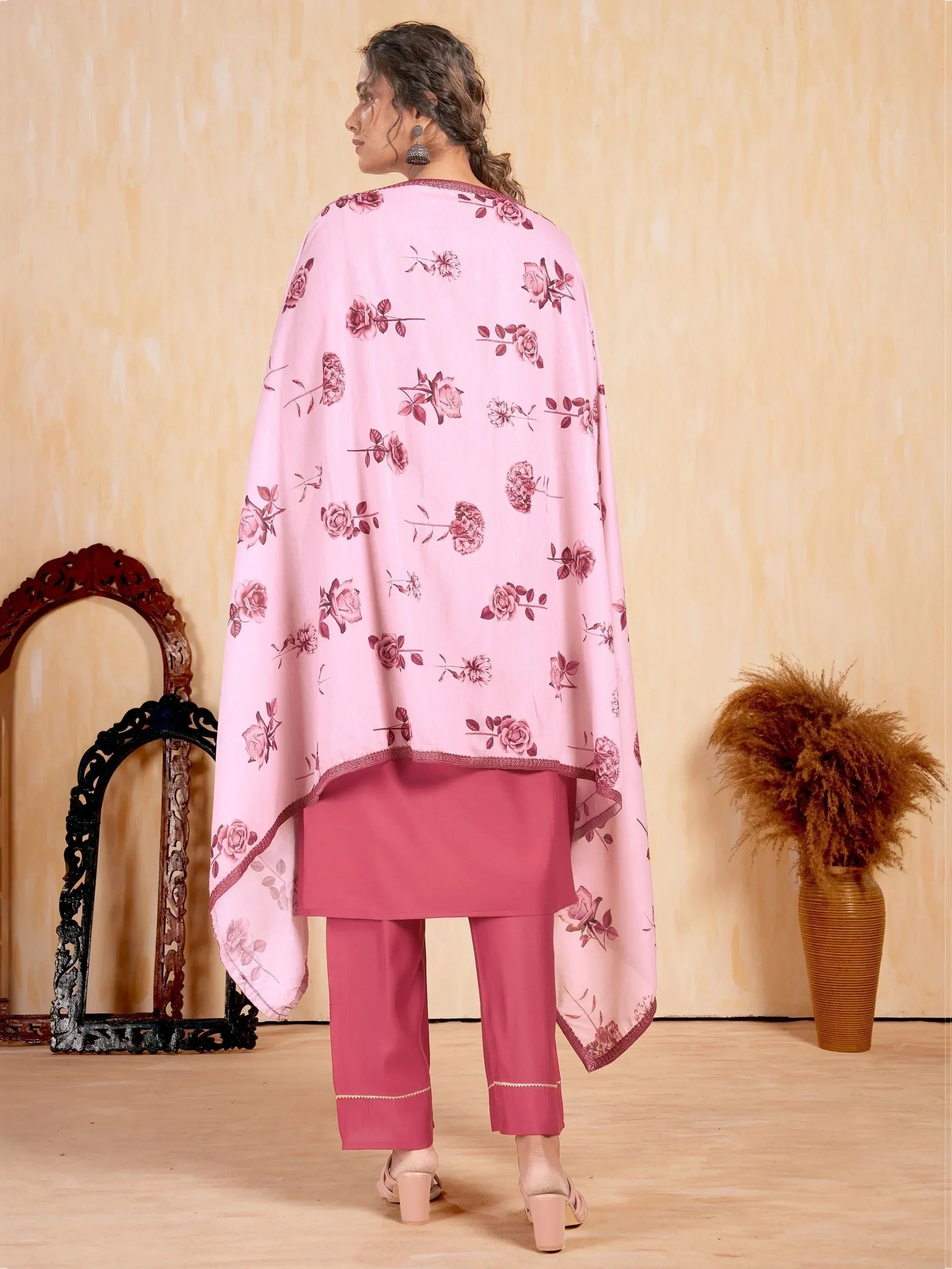 Woman wearing pink floral printed salwar kameez with dupatta, back view, indoors