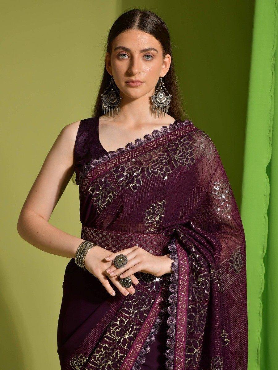 Elegant purple saree with gold floral embroidery and lace border, paired with statement earrings.