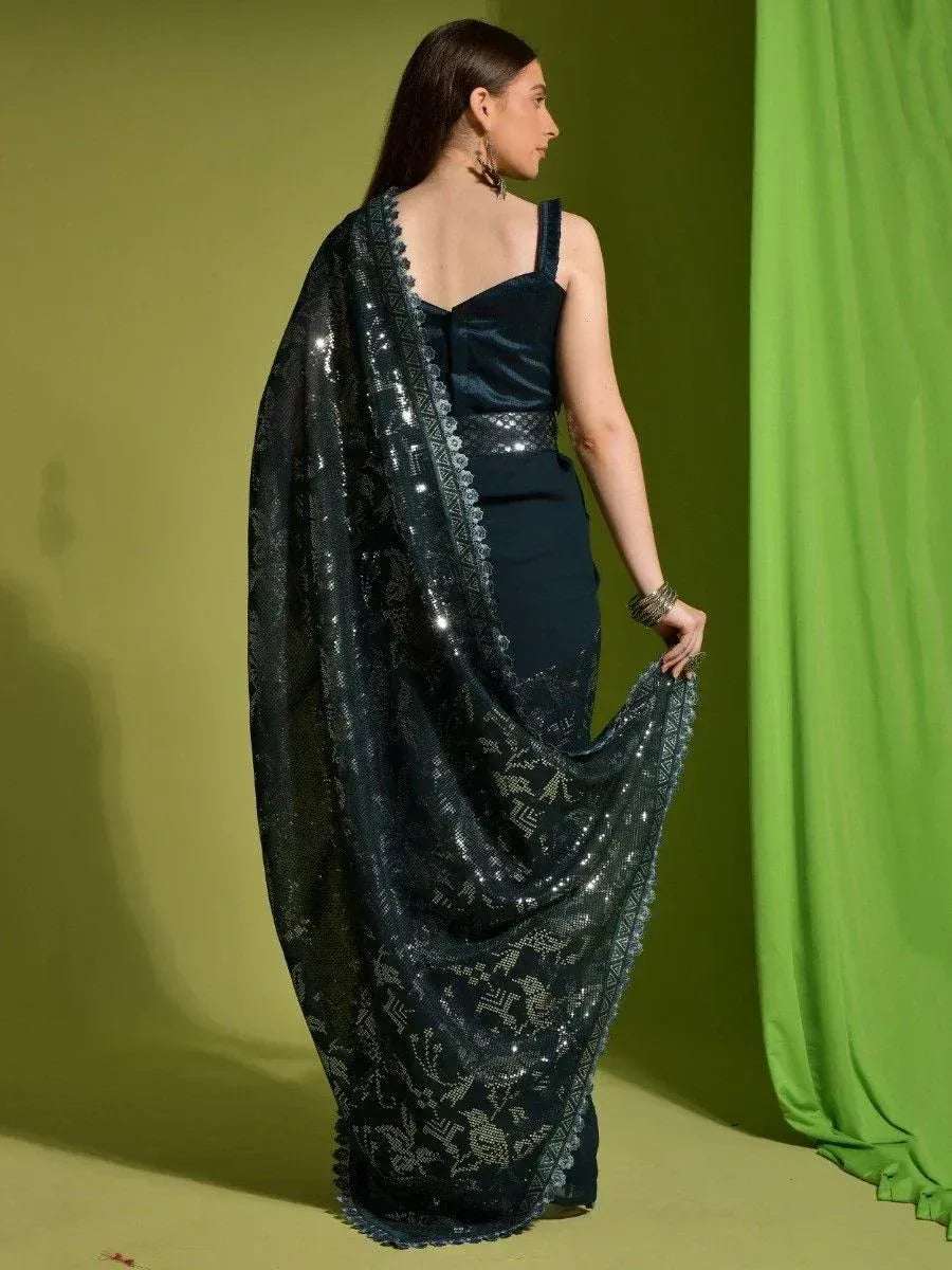Dark green sequined saree with floral embroidery, paired with a velvet blouse, perfect for Indian ethnic occasions.