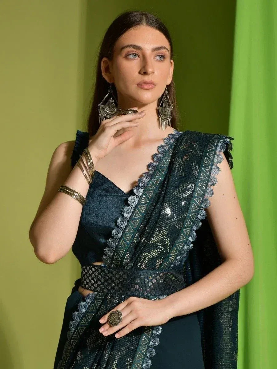 Elegant dark green saree with sequin work and lace border, paired with statement jewelry for Indian ethnic wear.