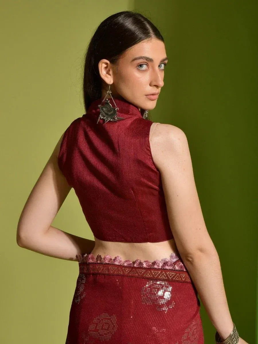 Maroon sleeveless ethnic blouse with high neck, paired with matching lehenga, ideal for Indian weddings and festive occasions.