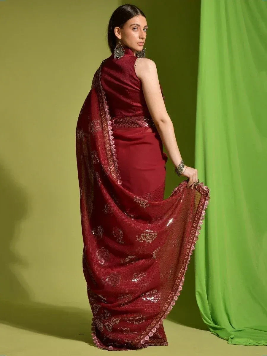 Maroon designer saree with gold embroidery and sequin work, styled with statement earrings for ethnic wear
