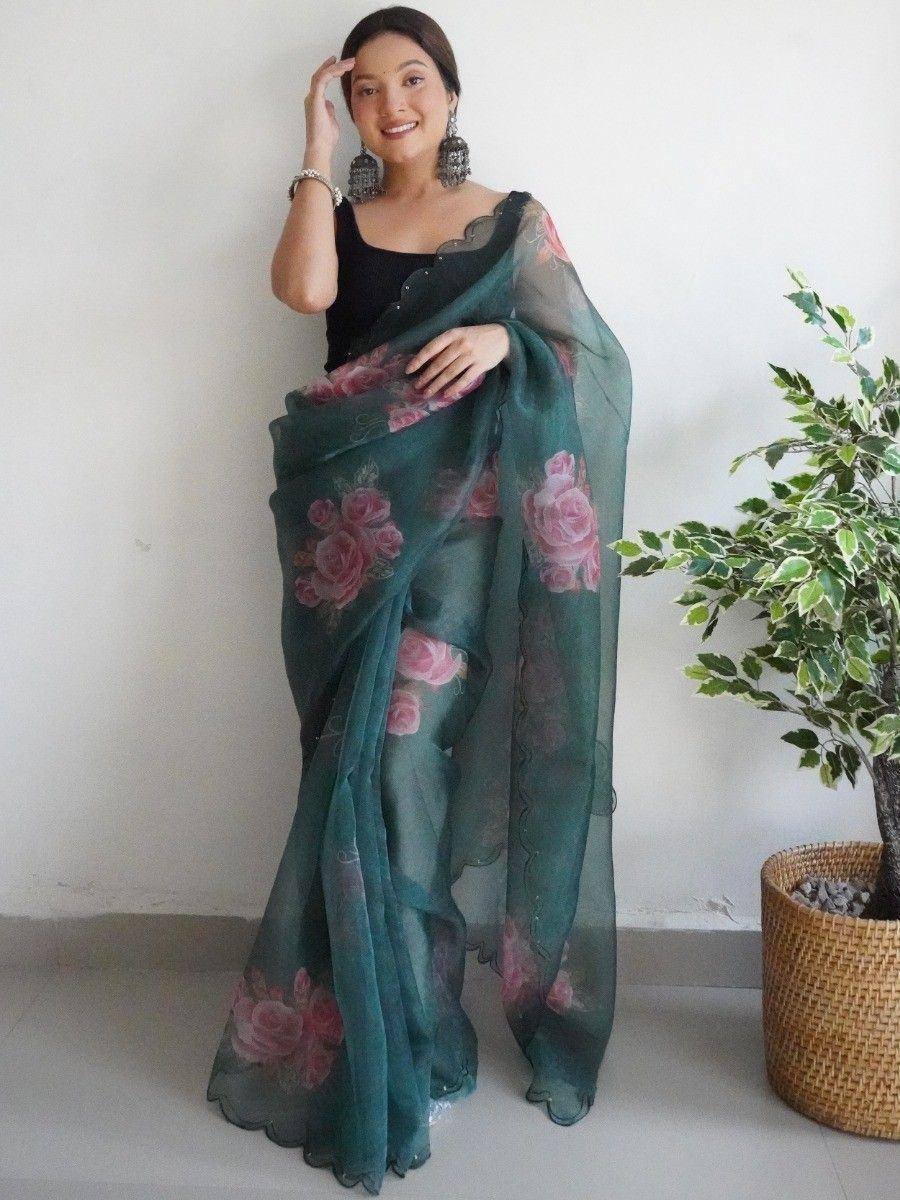 Woman in teal floral saree with pink roses, black blouse, ethnic wear
