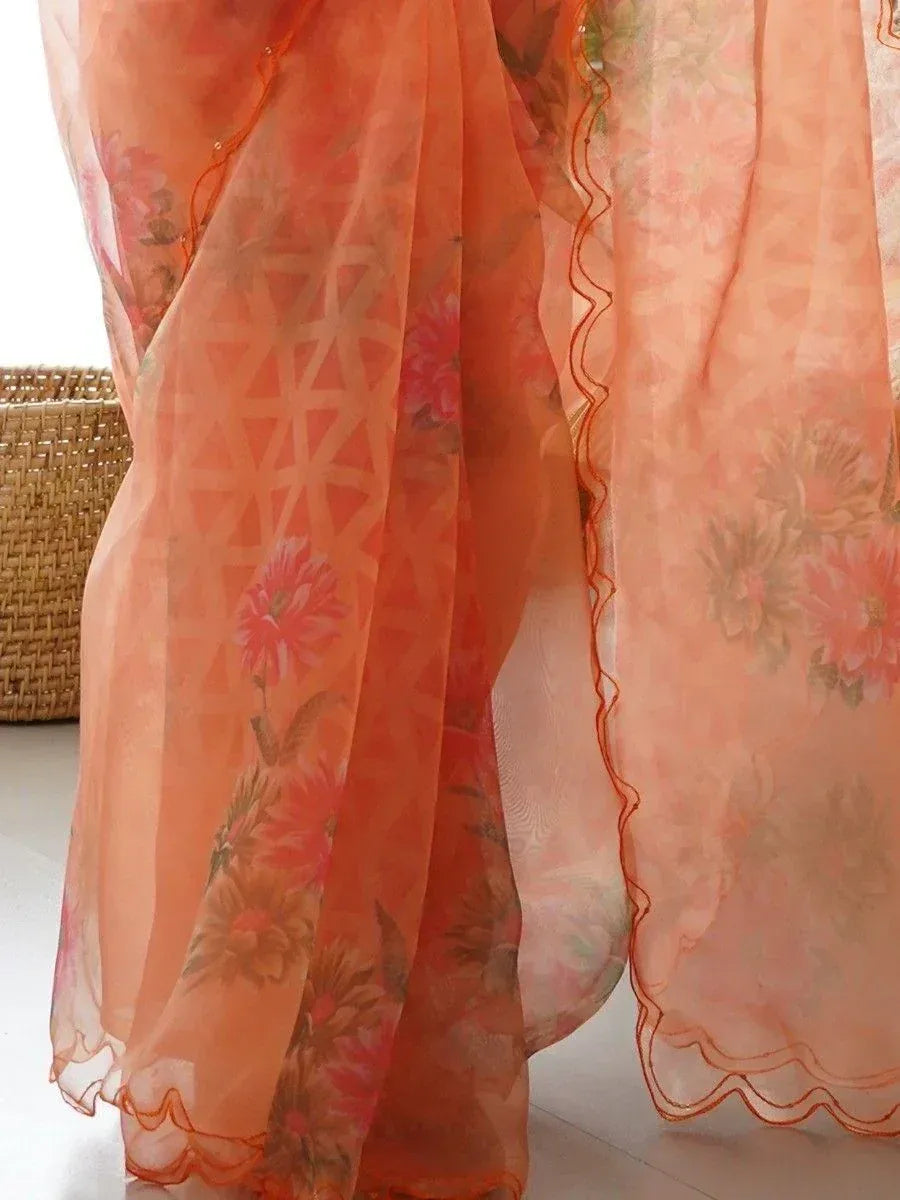 Orange floral printed ethnic saree with scalloped border, lightweight fabric for traditional Indian wear