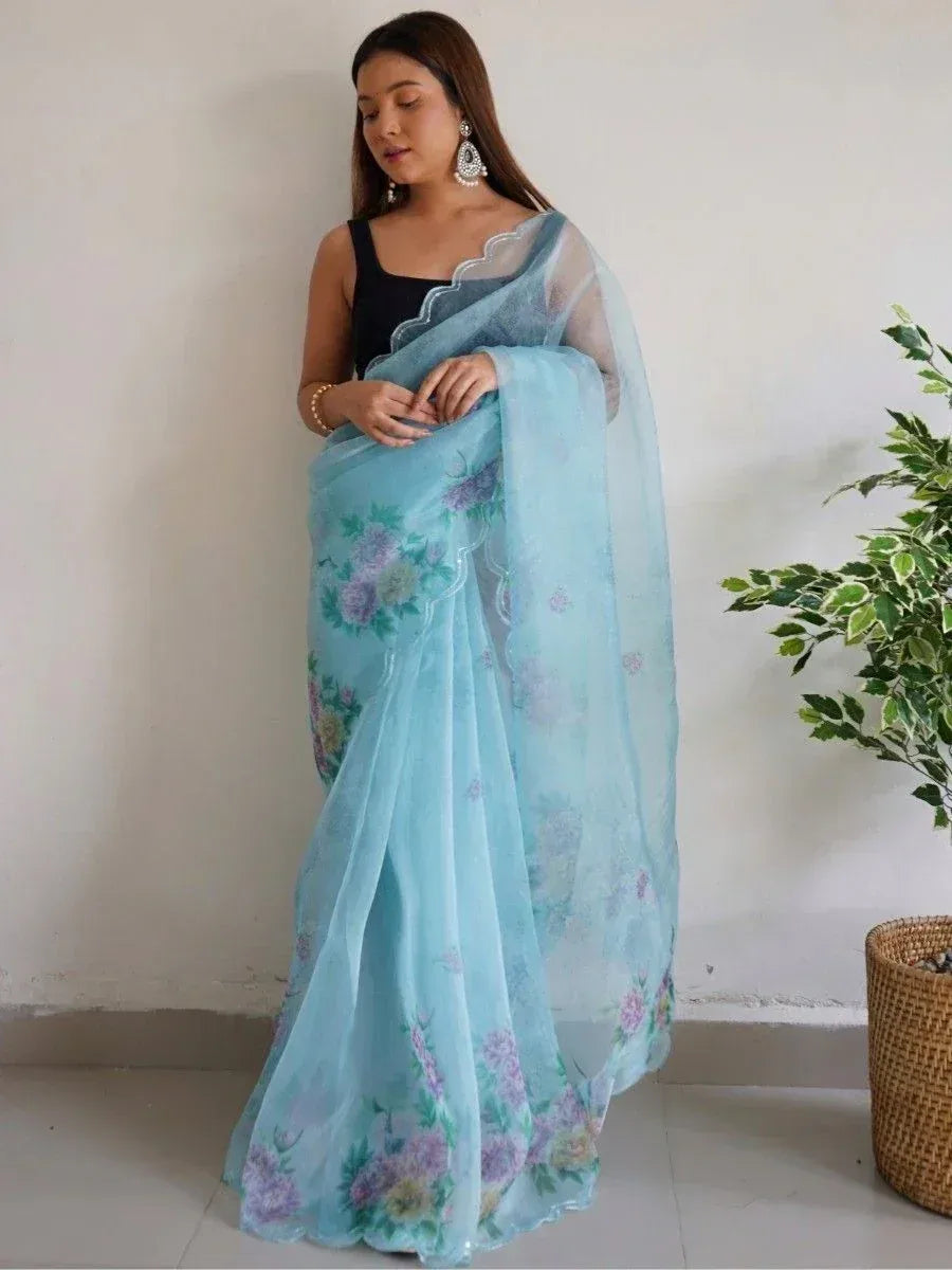 Light blue floral printed saree with scalloped border, paired with black blouse, ideal for ethnic occasions