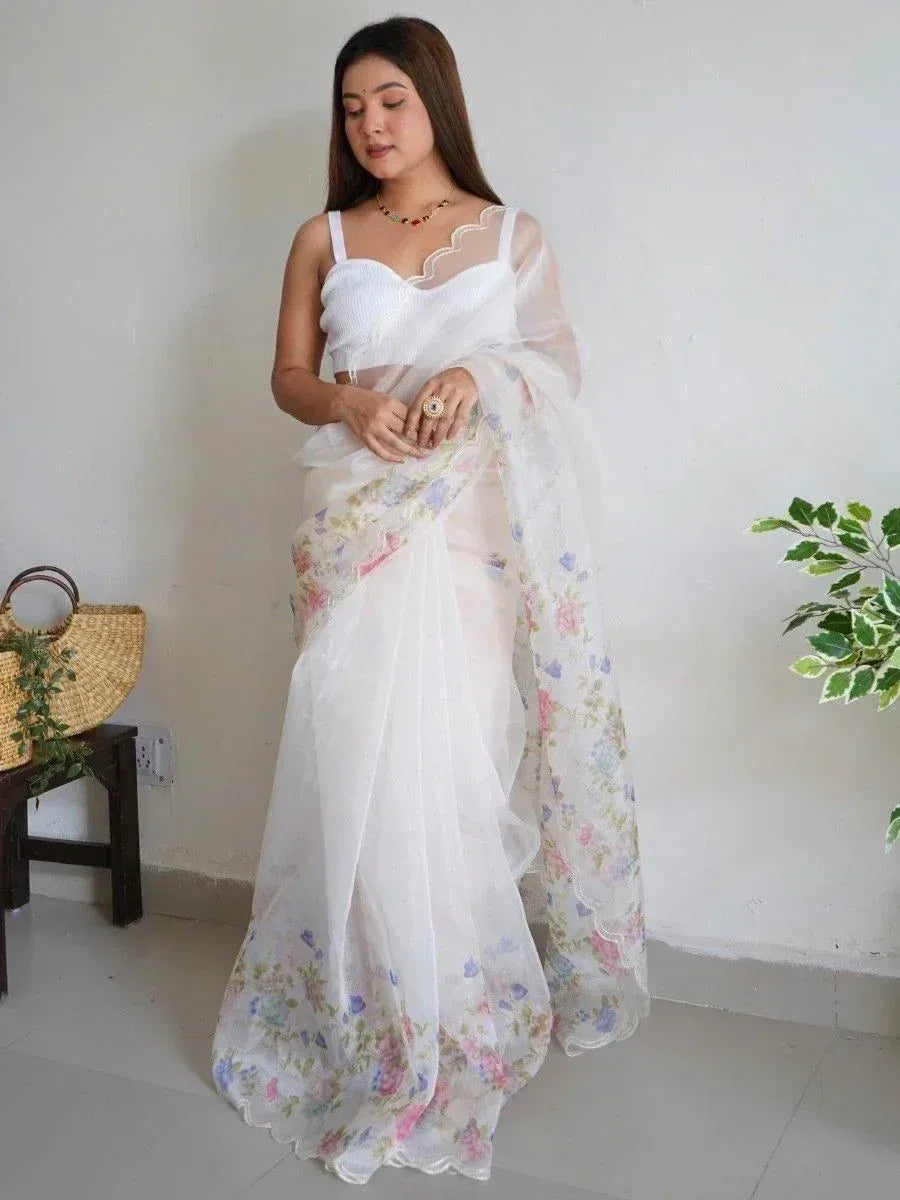 White floral saree with scalloped border, paired with sleeveless blouse, ideal for ethnic occasions