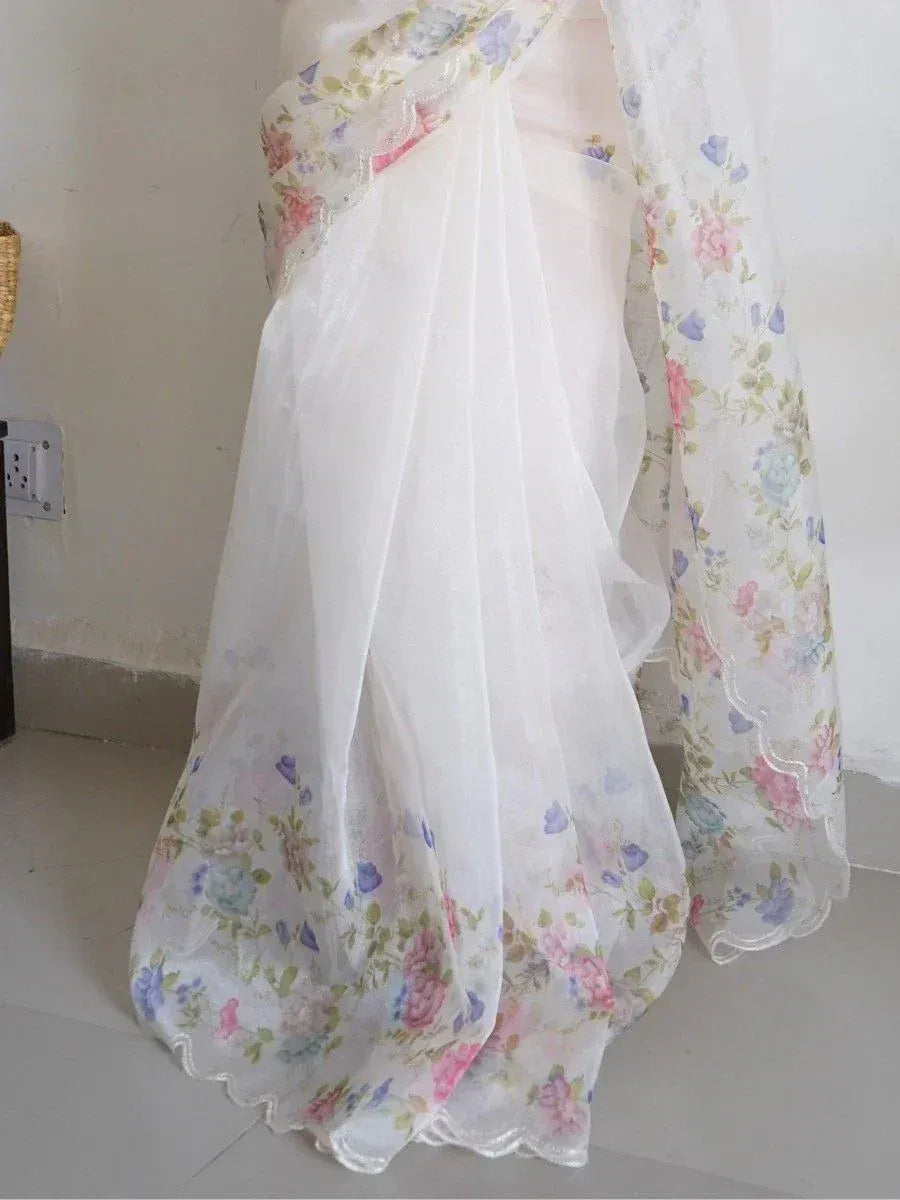 White floral saree with pastel print and scalloped border, ideal for ethnic occasions
