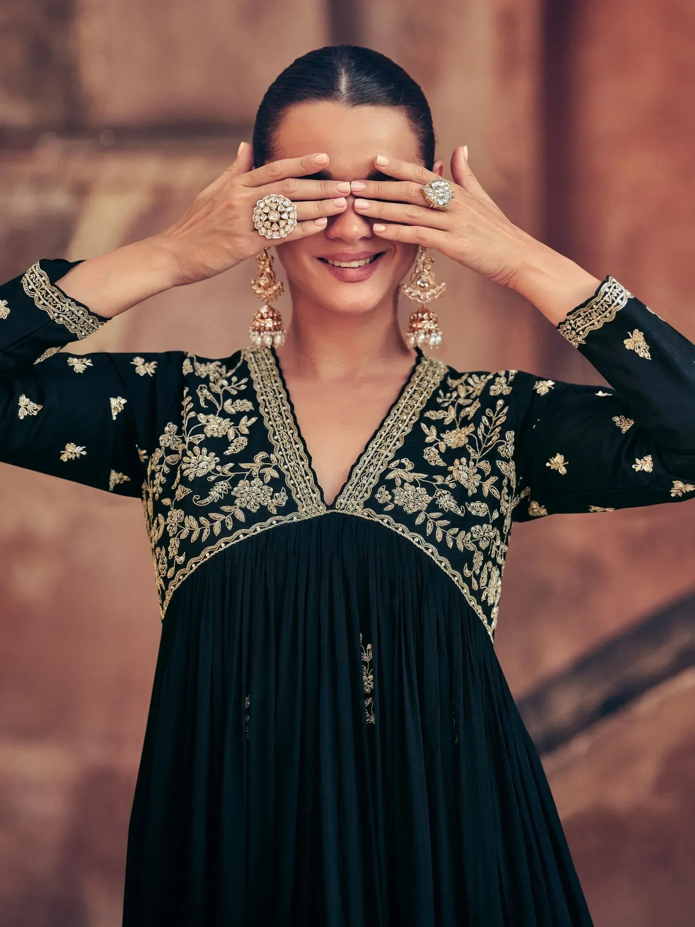 Black ethnic gown with gold embroidery, floral design, and traditional jewelry for festive occasions