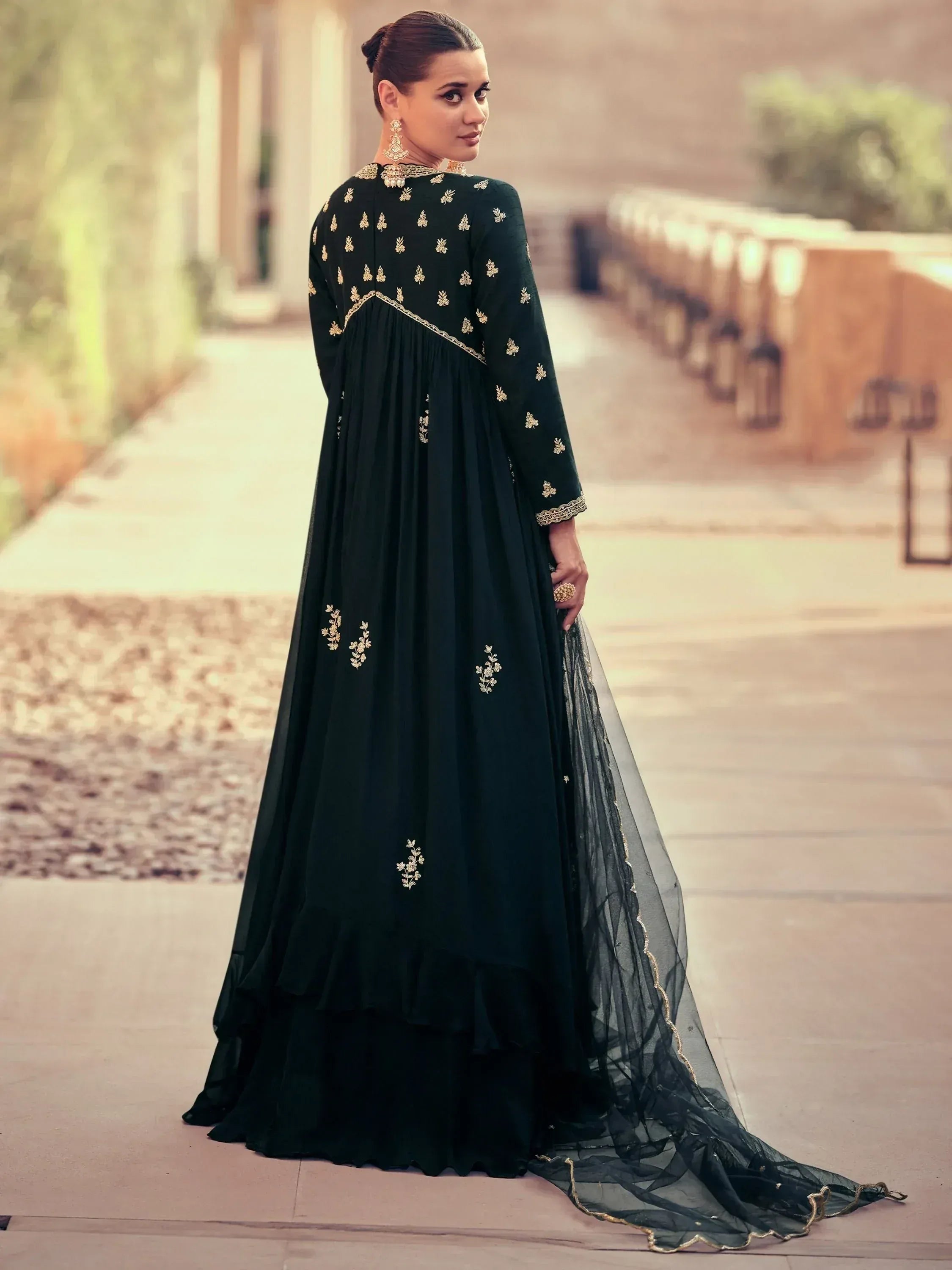 Elegant dark green ethnic gown with gold embroidery, perfect for Indian weddings and festive occasions.