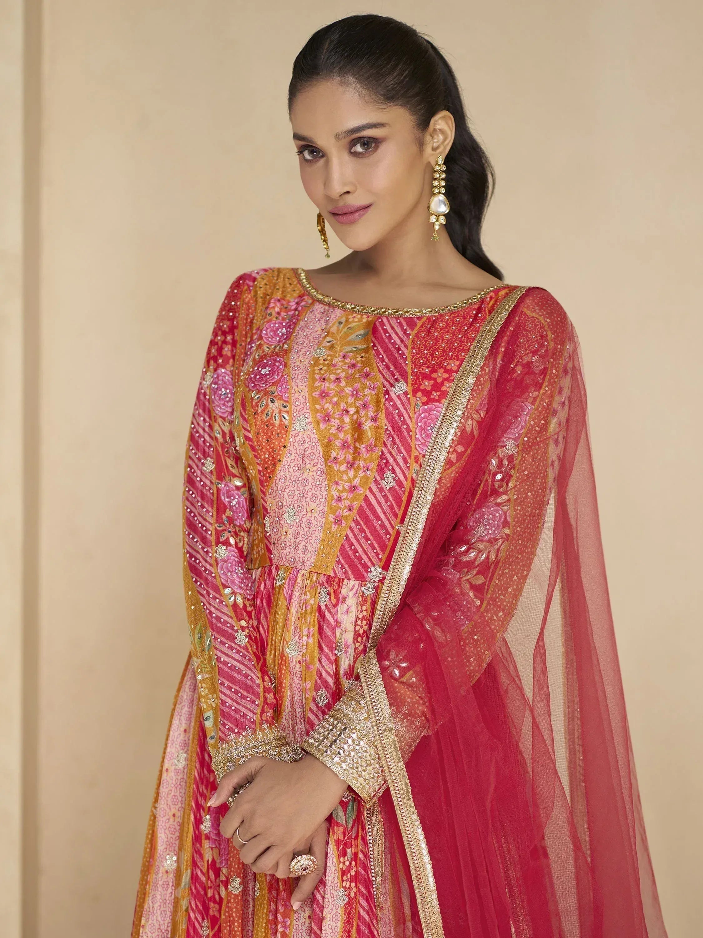 Elegant pink and gold embroidered Indian ethnic gown with floral patterns and sheer sleeves