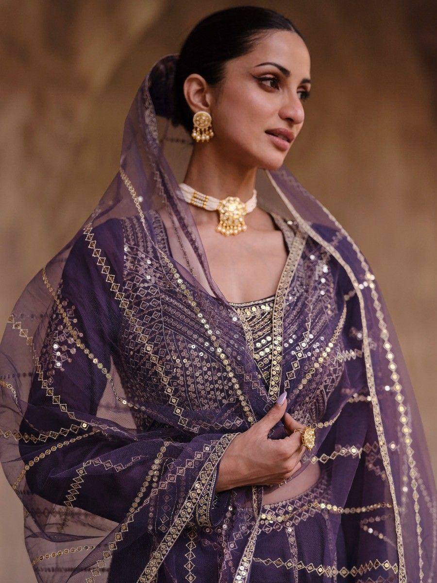 Elegant purple ethnic salwar kameez with gold embroidery and sheer dupatta, perfect for festive occasions.