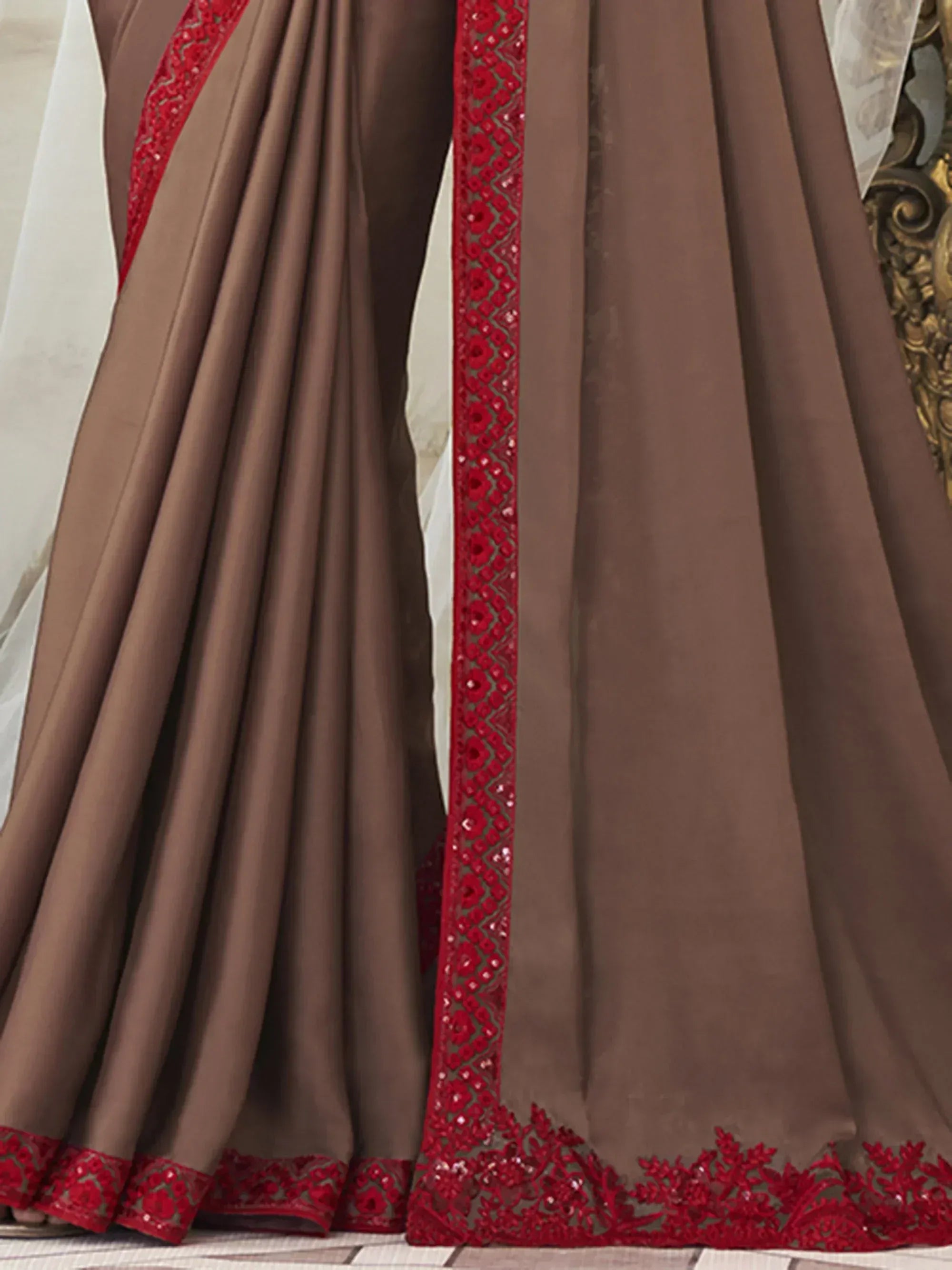 Brown ethnic gown with red floral embroidery and sequin detailing, perfect for festive occasions.