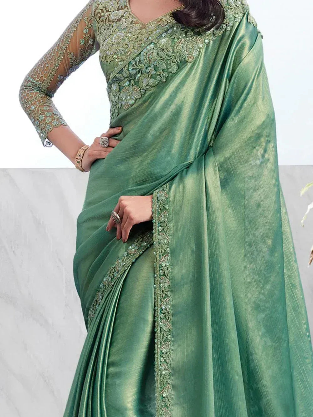 Emerald green designer saree with heavy embroidery and sheer sleeves, perfect for Indian ethnic occasions