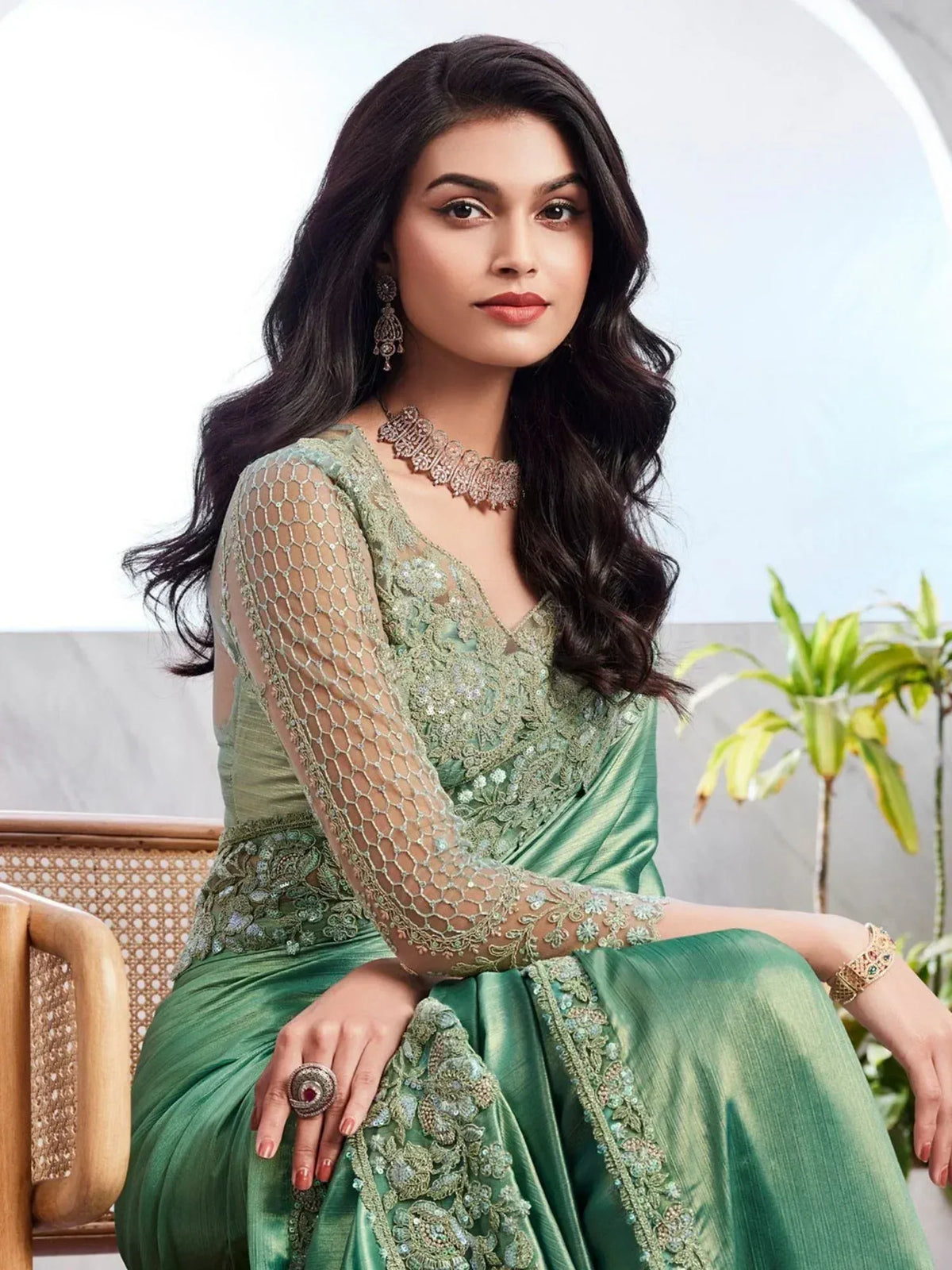 Elegant green designer saree with intricate embroidery and sheer sleeves, perfect for ethnic occasions.