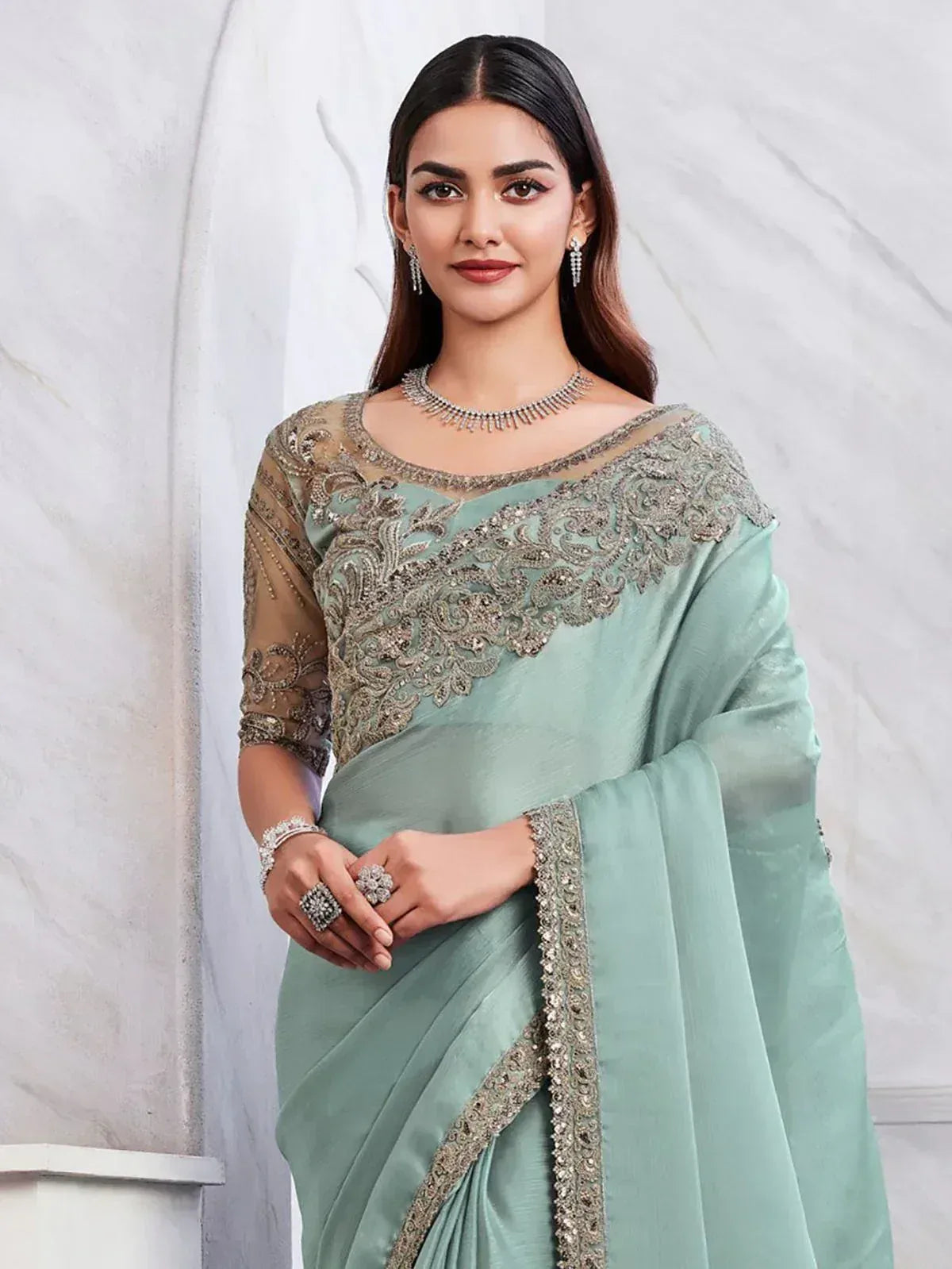 Mint green designer saree with heavy silver embroidery and sheer blouse, perfect for Indian ethnic occasions.