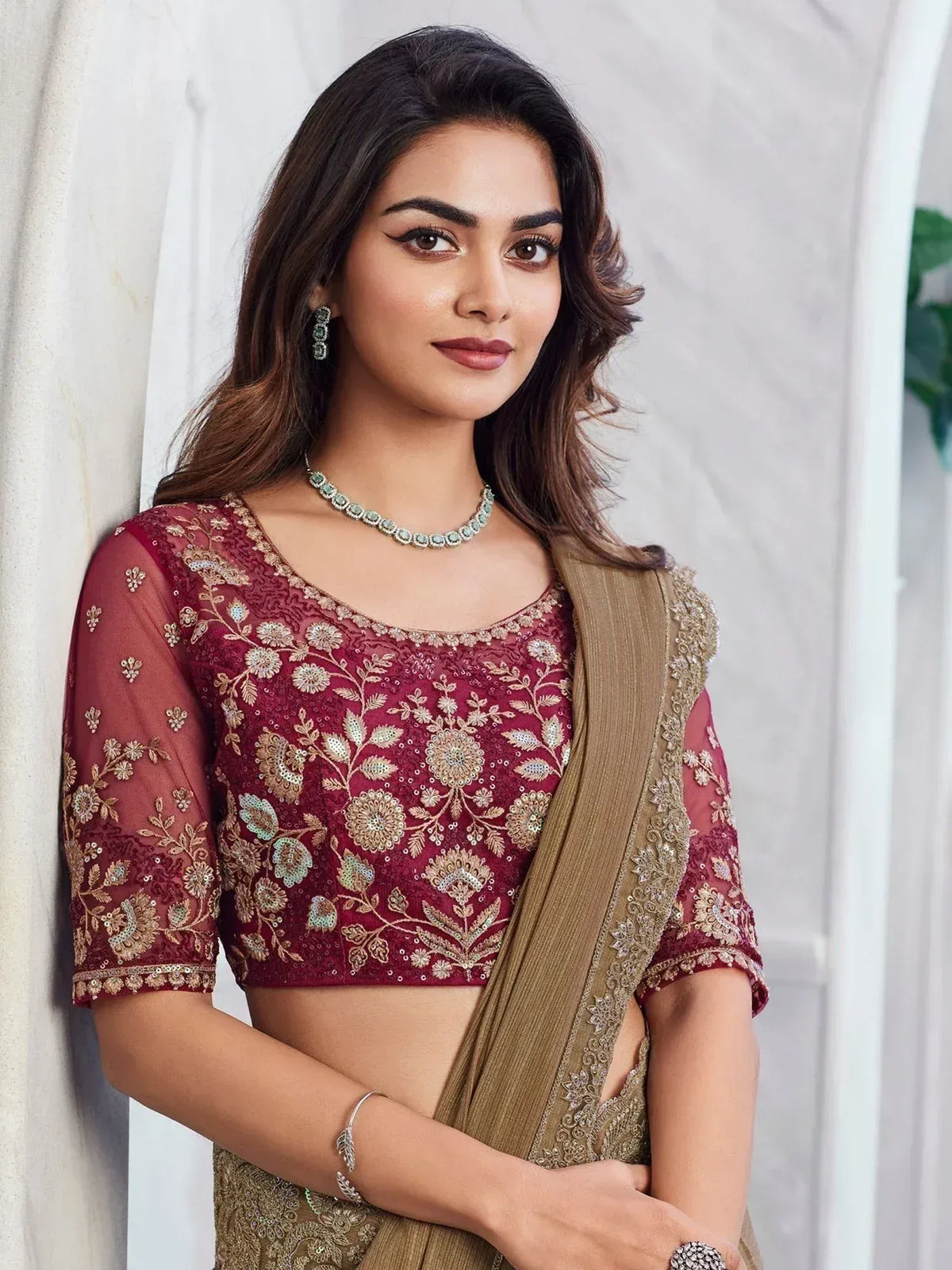 Maroon embroidered blouse with gold floral work, paired with olive green saree for Indian ethnic wear