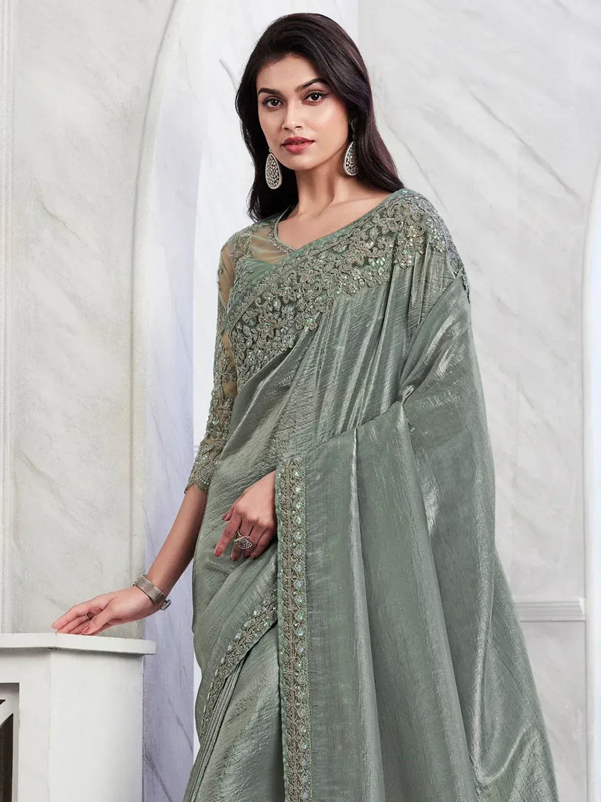 Elegant sage green saree with intricate embroidery and sheer blouse, perfect for ethnic occasions.