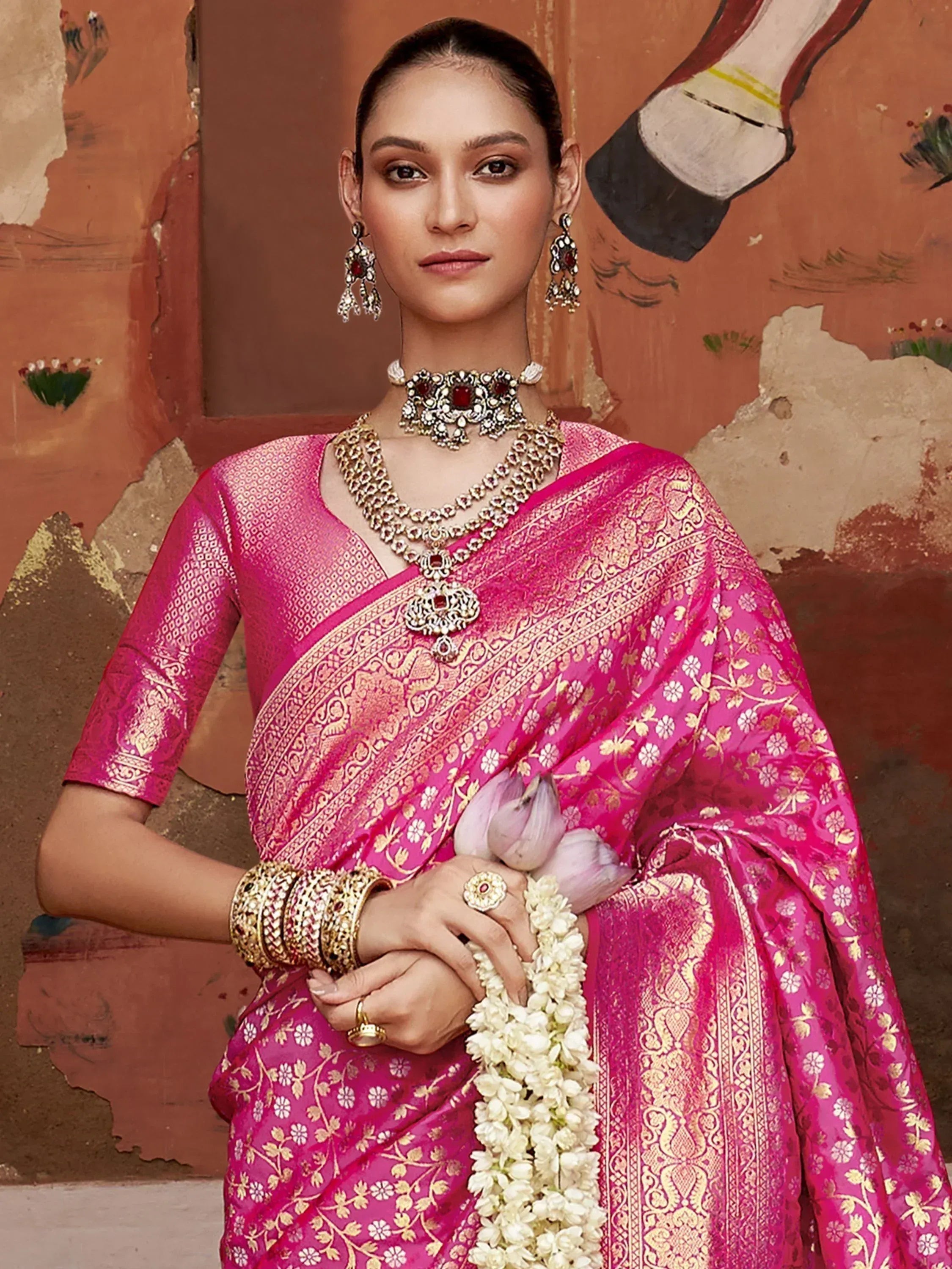 Pink floral saree with gold embroidery, traditional Indian ethnic wear, paired with temple jewelry and jasmine garland