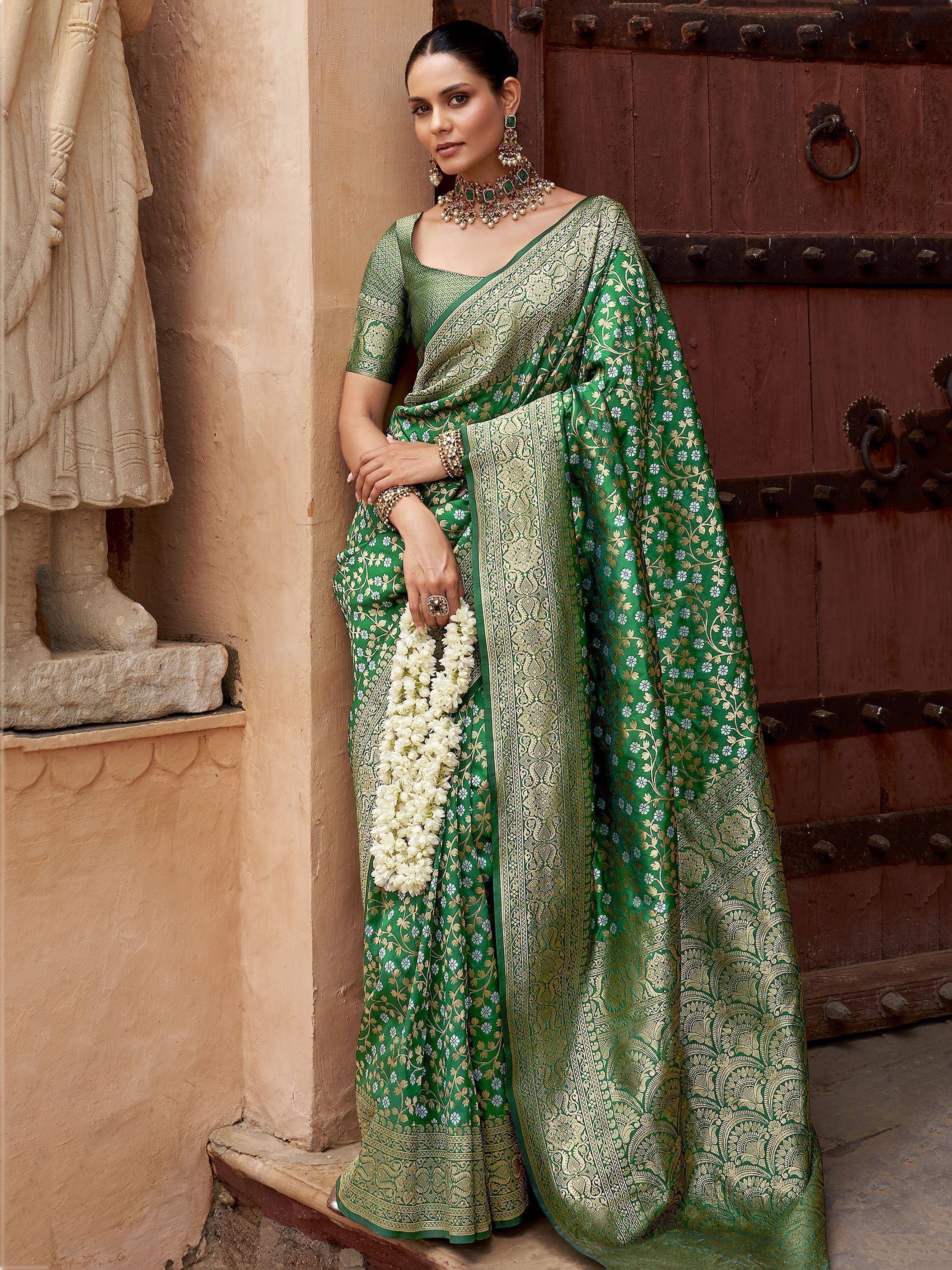 Elegant green and gold floral saree with intricate border, styled with traditional jewelry for ethnic occasions.