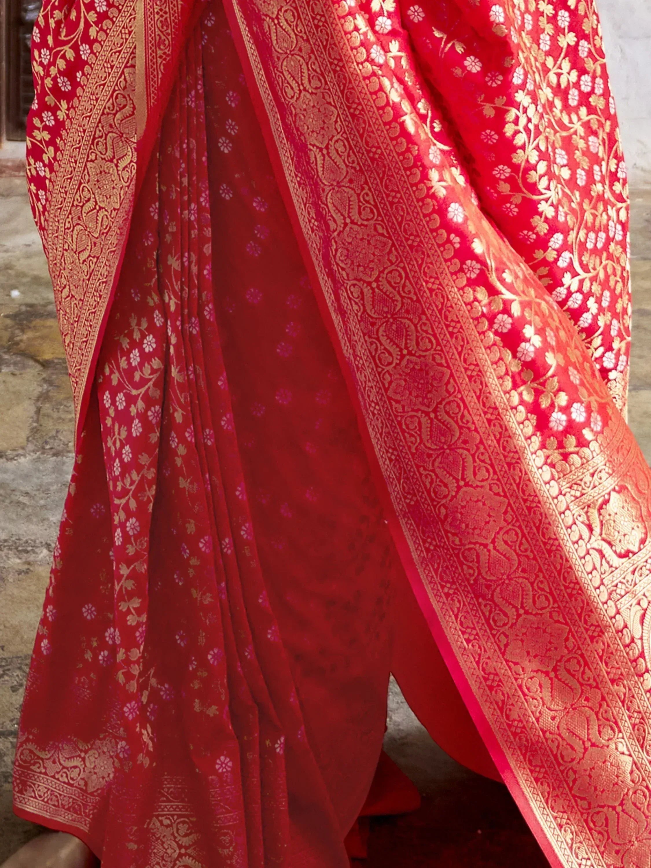 Red ethnic saree with gold floral and paisley embroidery, perfect for Indian weddings and festivals.