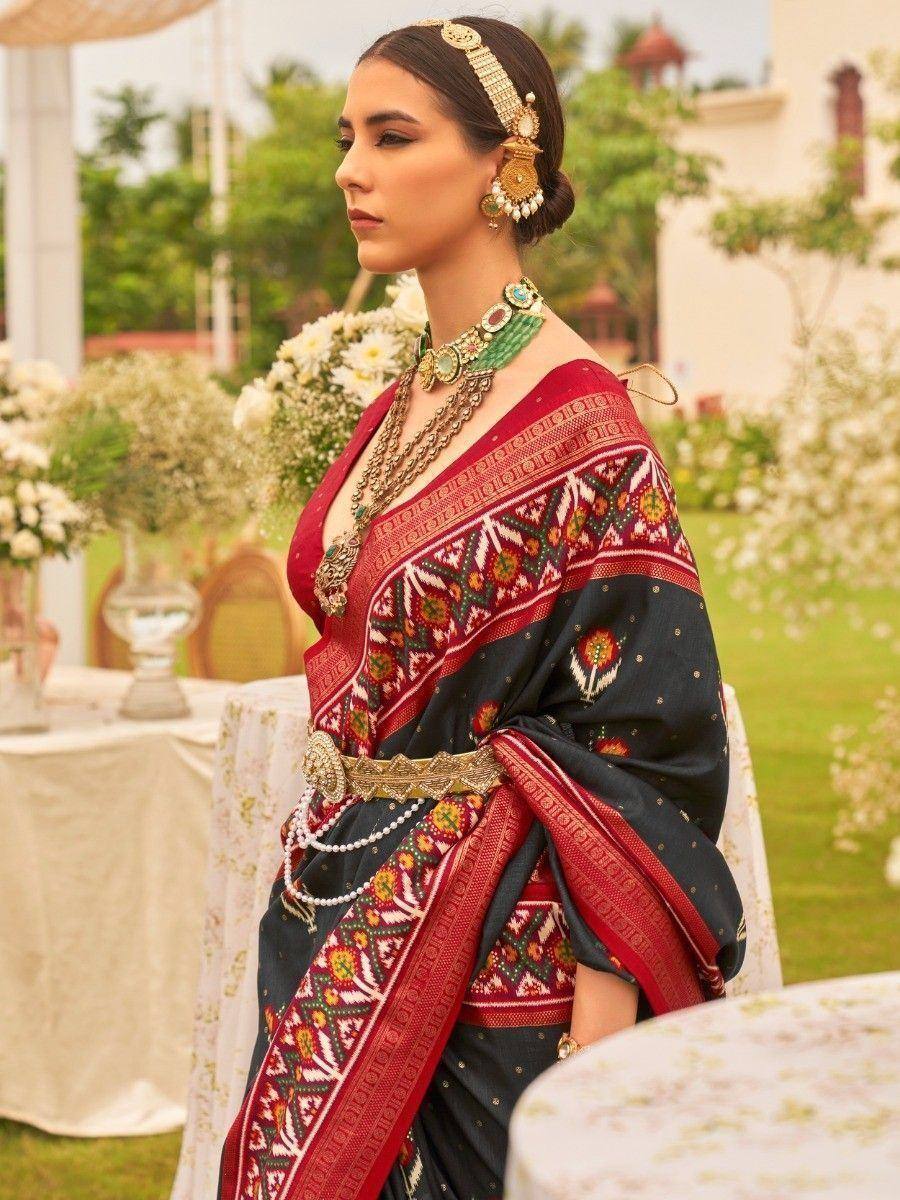 Elegant woman in black and red ethnic saree with intricate embroidery and traditional jewelry