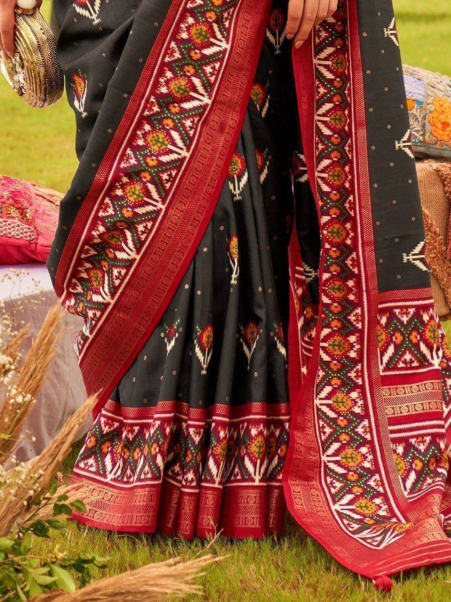 Black saree with red and green ethnic embroidery, perfect for traditional Indian occasions.