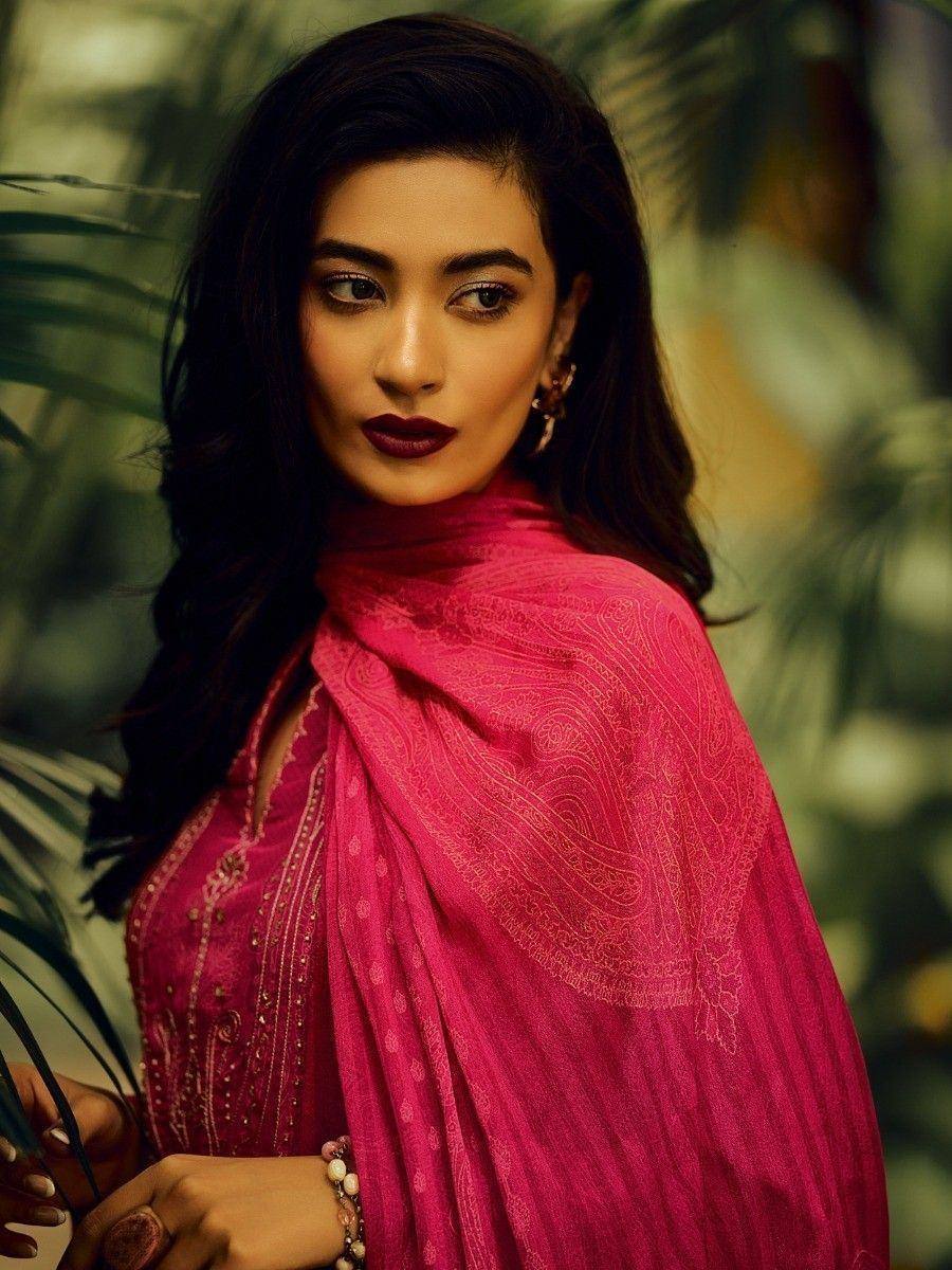 Woman in vibrant pink embroidered ethnic wear with matching dupatta, styled for festive occasions