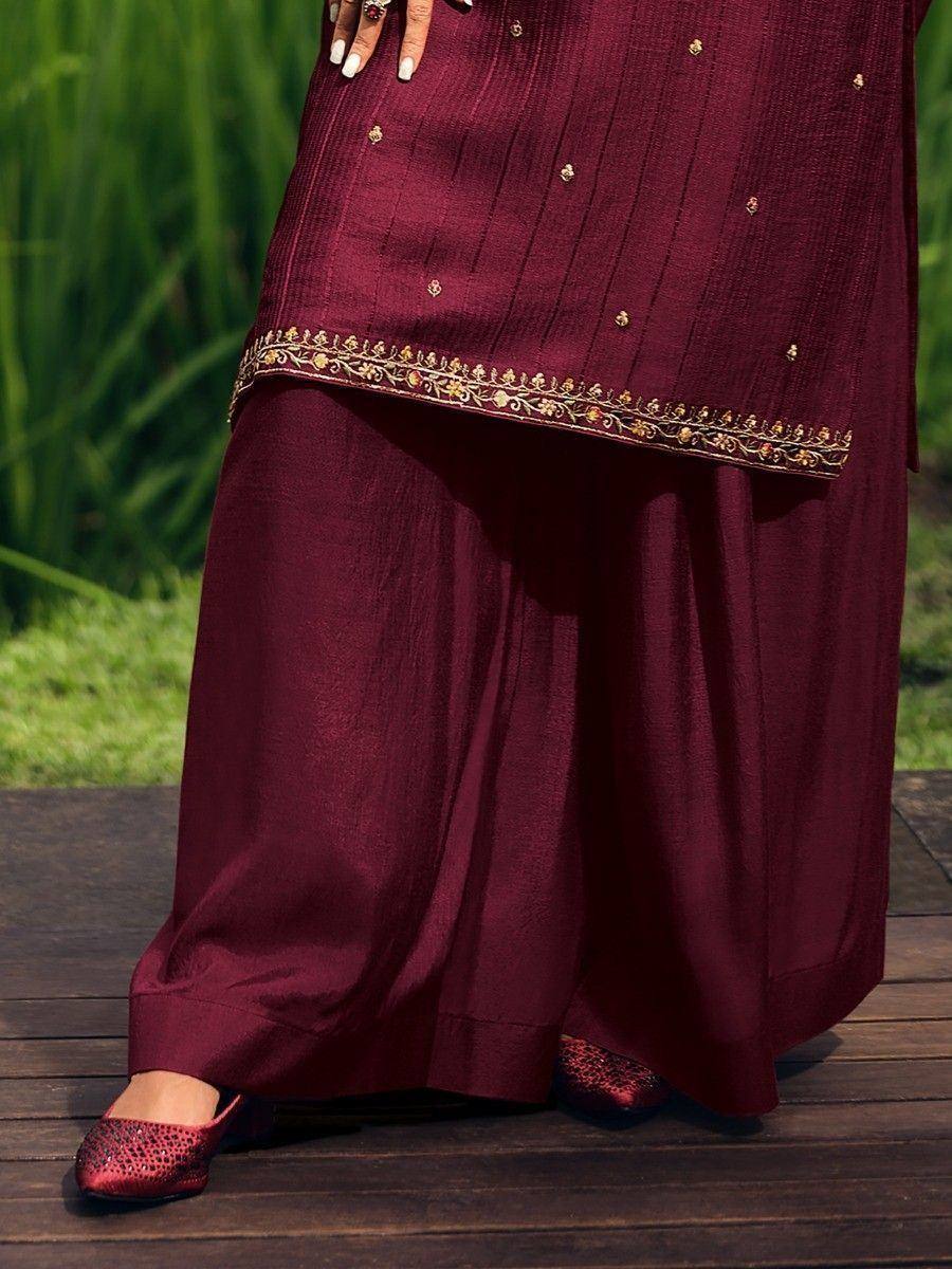 Maroon ethnic salwar kameez with gold embroidery, paired with matching embellished flats, perfect for festive occasions.
