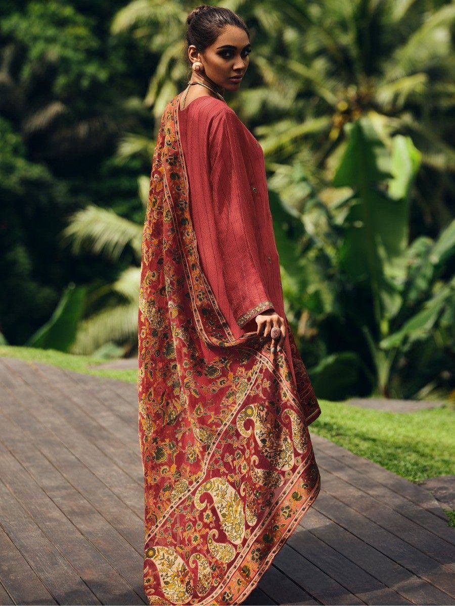 Elegant red ethnic gown with floral paisley print, styled outdoors on a wooden pathway.